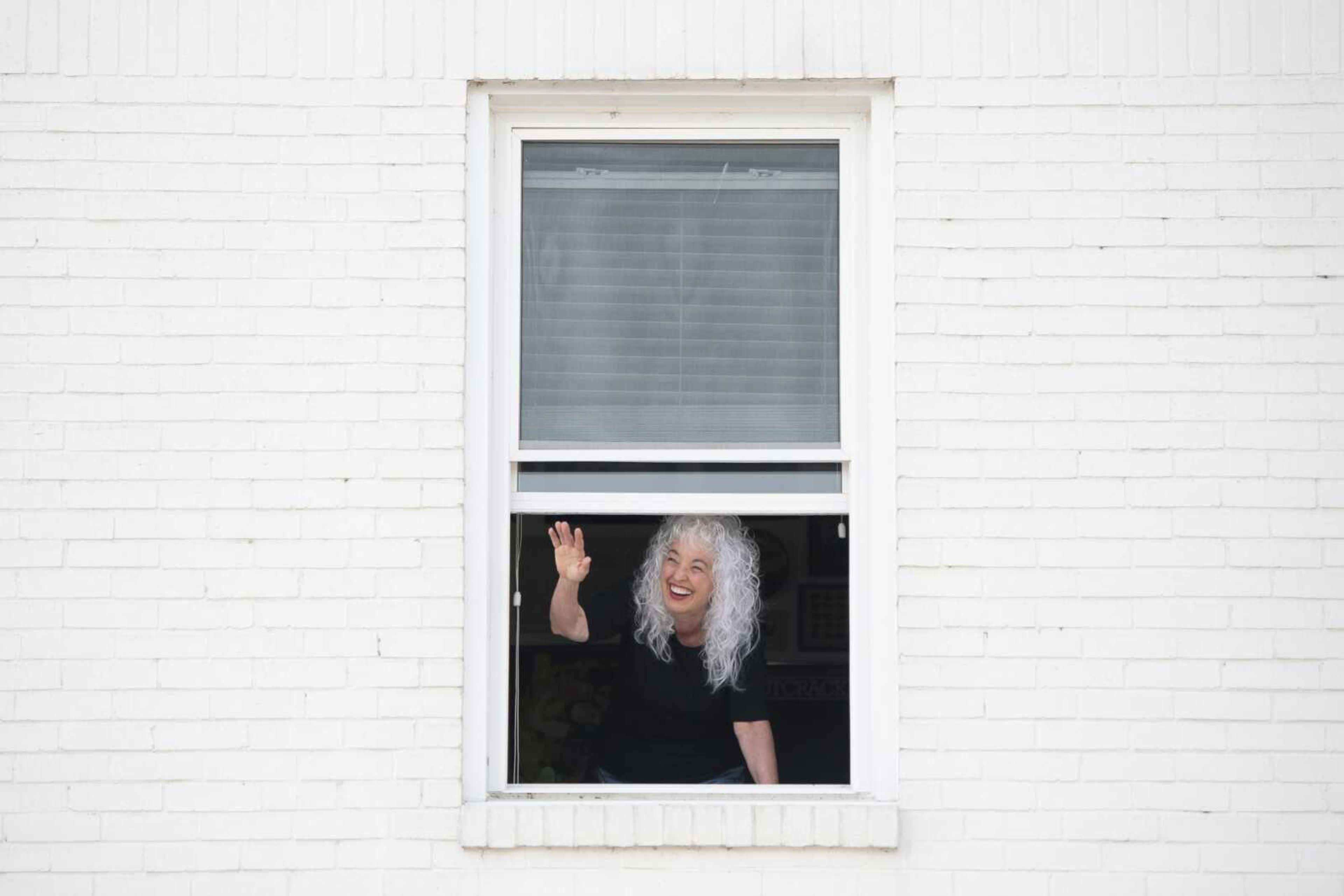 Gail Lowrance of Cape Girardeau waves to a passerby while taking a portrait Tuesday at her apartment in Cape Girardeau.