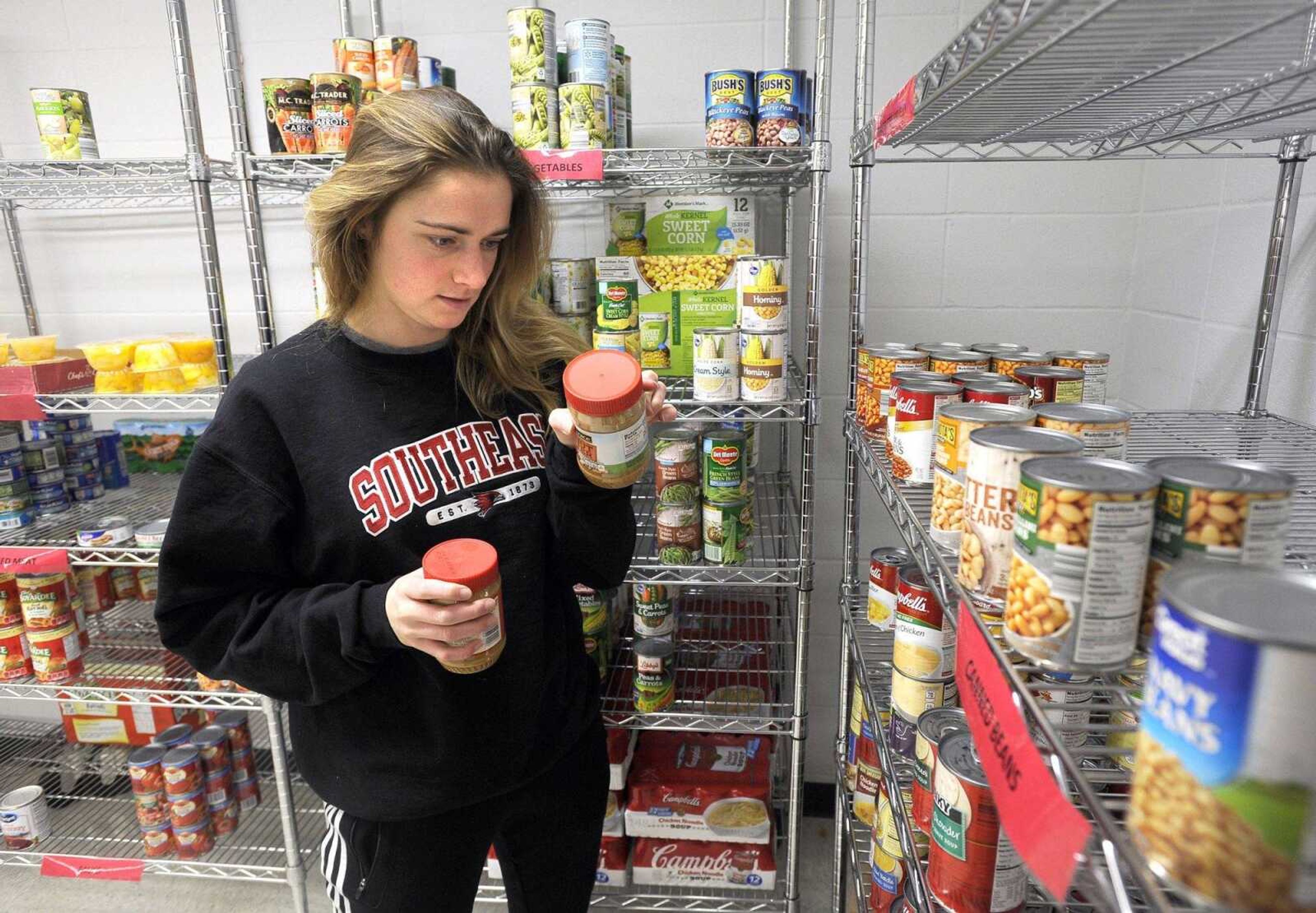 Amy Krebs, student manager at the Redhawk Food Pantry, checks a food donation Thursday for its expiration date.