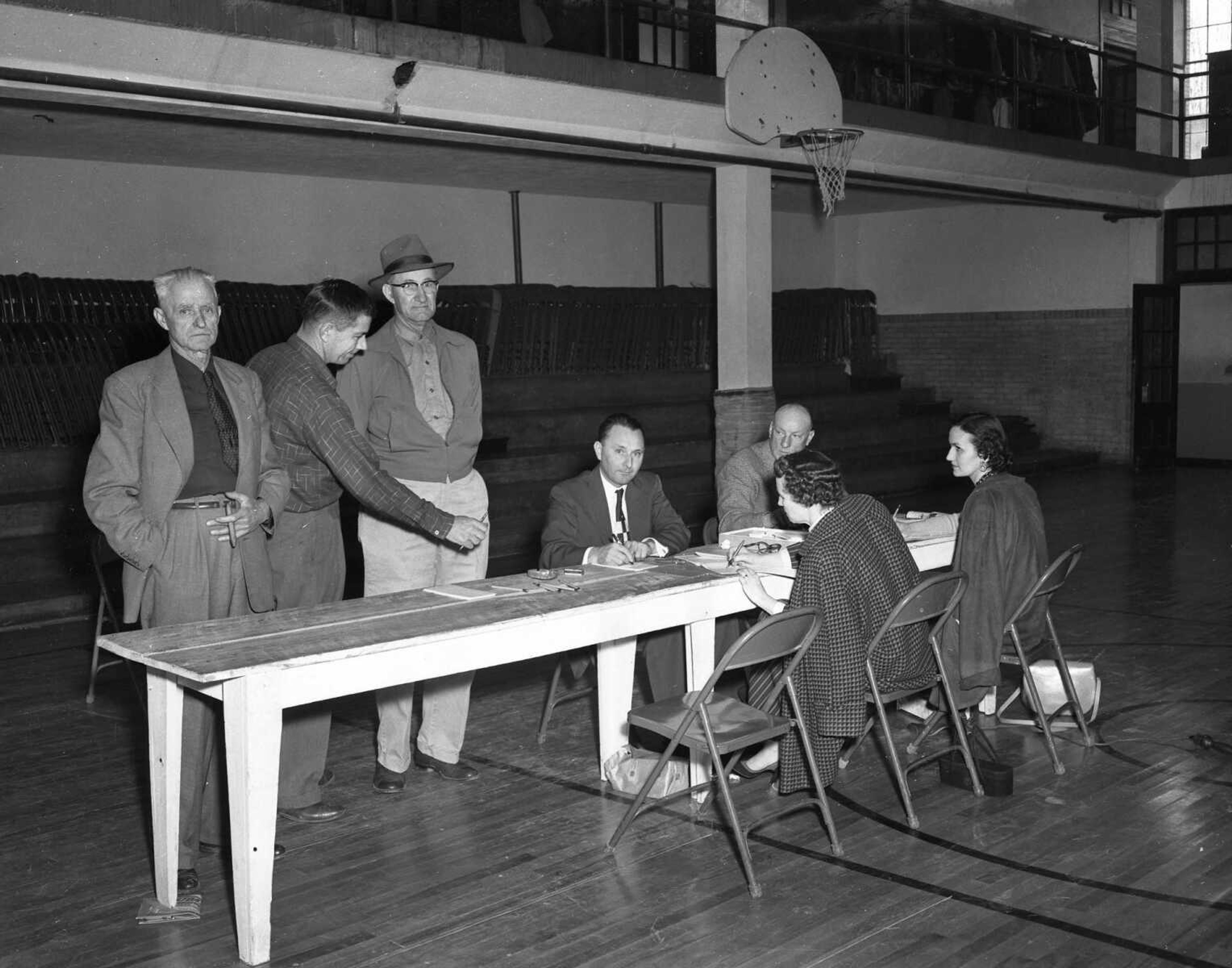 What are these serious-looking people doing? Casting votes?