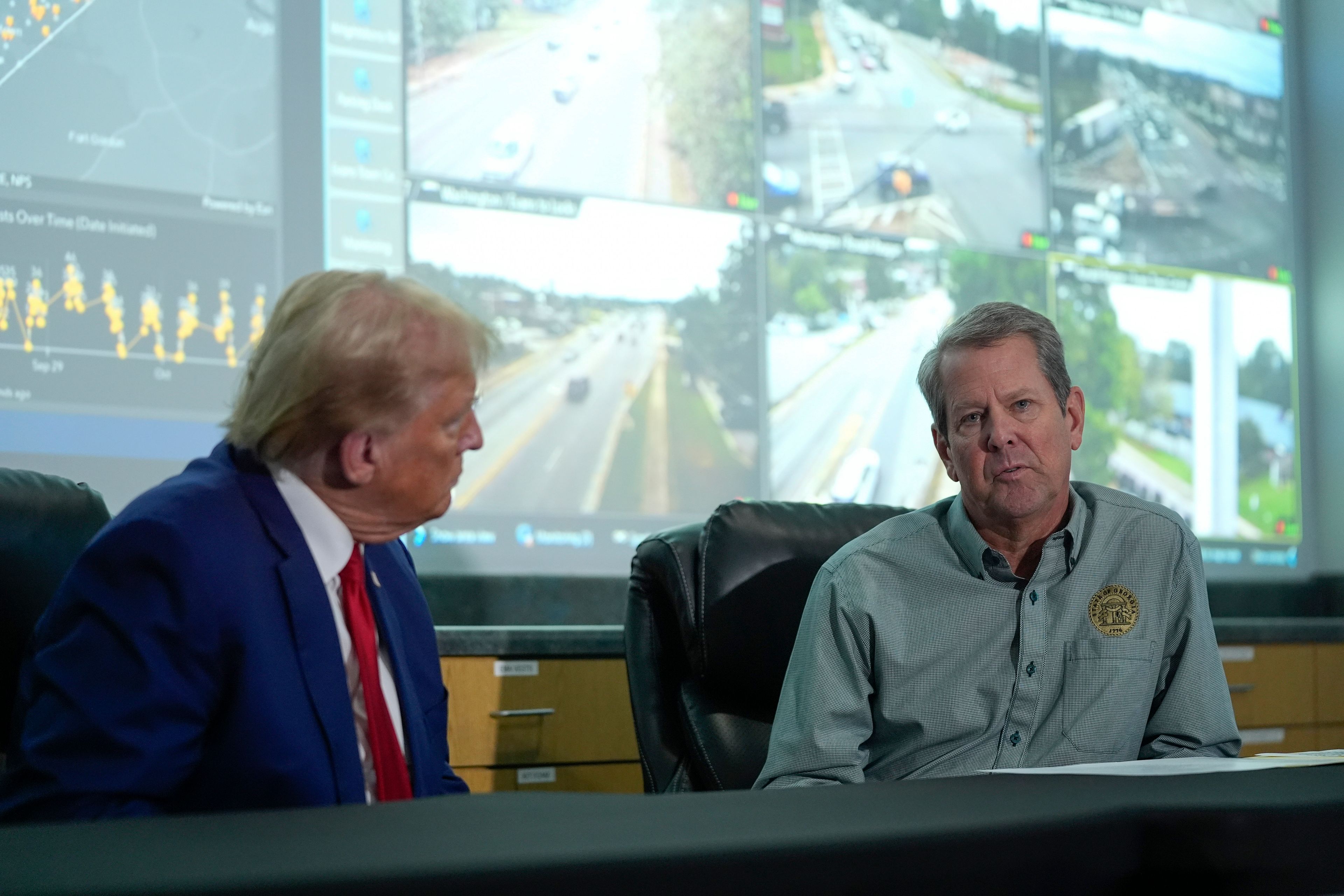 Republican presidential nominee former President Donald Trump talks with Georgia Gov. Brian Kemp during a briefing at the Columbia County Emergency Management Agency as he visits areas impacted by Hurricane Helene, Friday, Oct. 4, 2024, in Evans, Ga. (AP Photo/Evan Vucci)