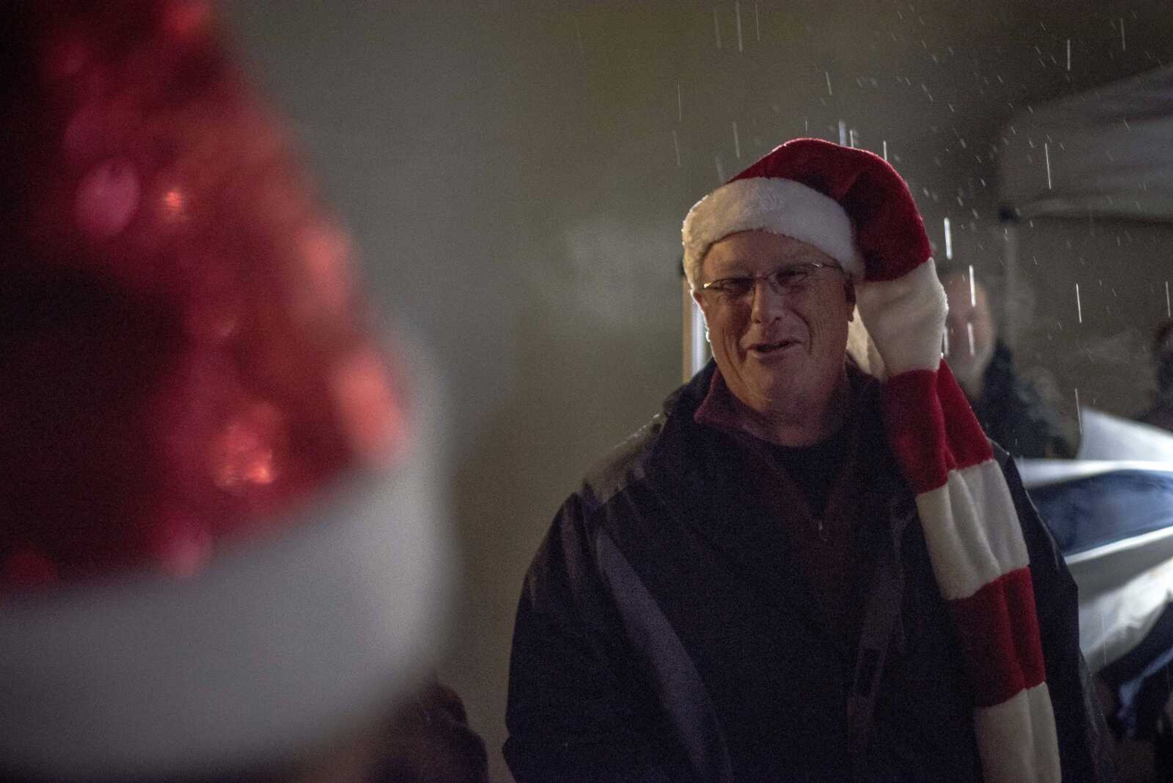 Caroler George Yoffie talks with other carolers while standing in the rain during the inaugural Christmas tree lighting hosted by Old Town Cape Friday, Nov. 29, 2019, at the Vasterling Suites in Cape Girardeau.