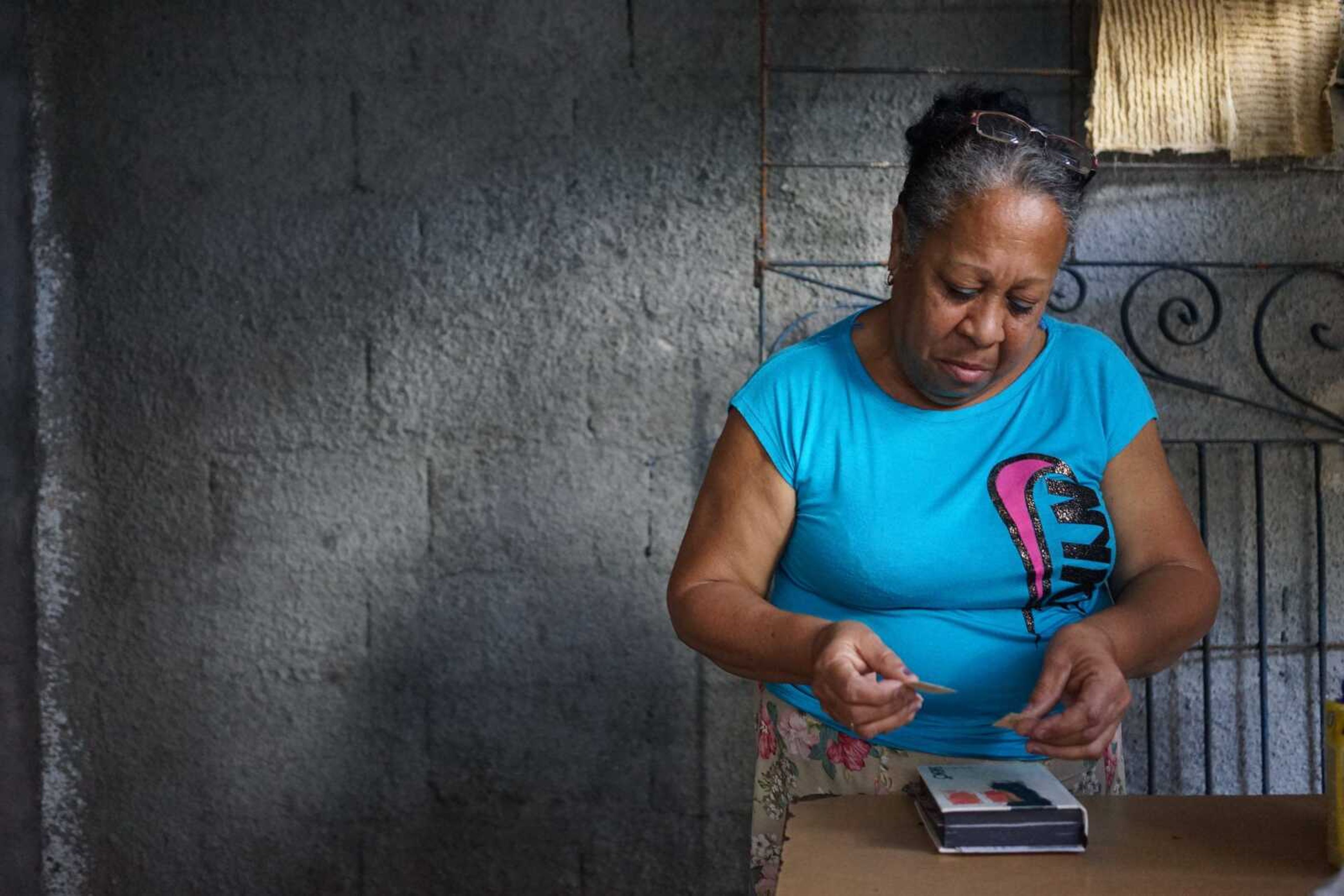 Nancy Belcourt looks at family photos Wednesday in her home in Santa Clara, Cuba. When Belcourt was a girl, two of her uncles fled their home in the central Cuban countryside to join rebels fighting a counter-revolution against Fidel Castro.