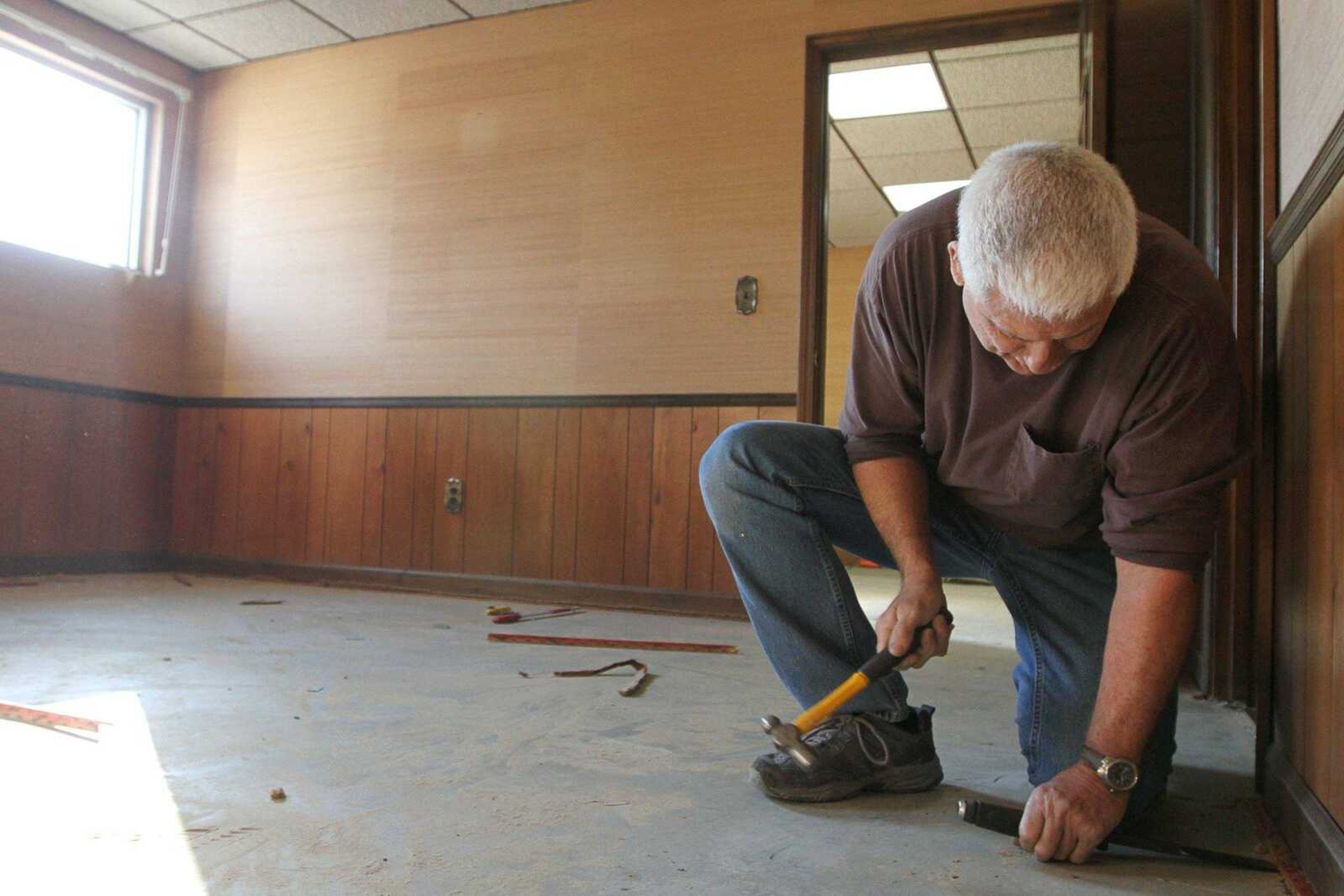 Keith Farmer, a Scott City Chamber of Commerce member, removes a carpet tack strip during renovations Dec. 12 at the chamber's new location. (Glenn Landberg)