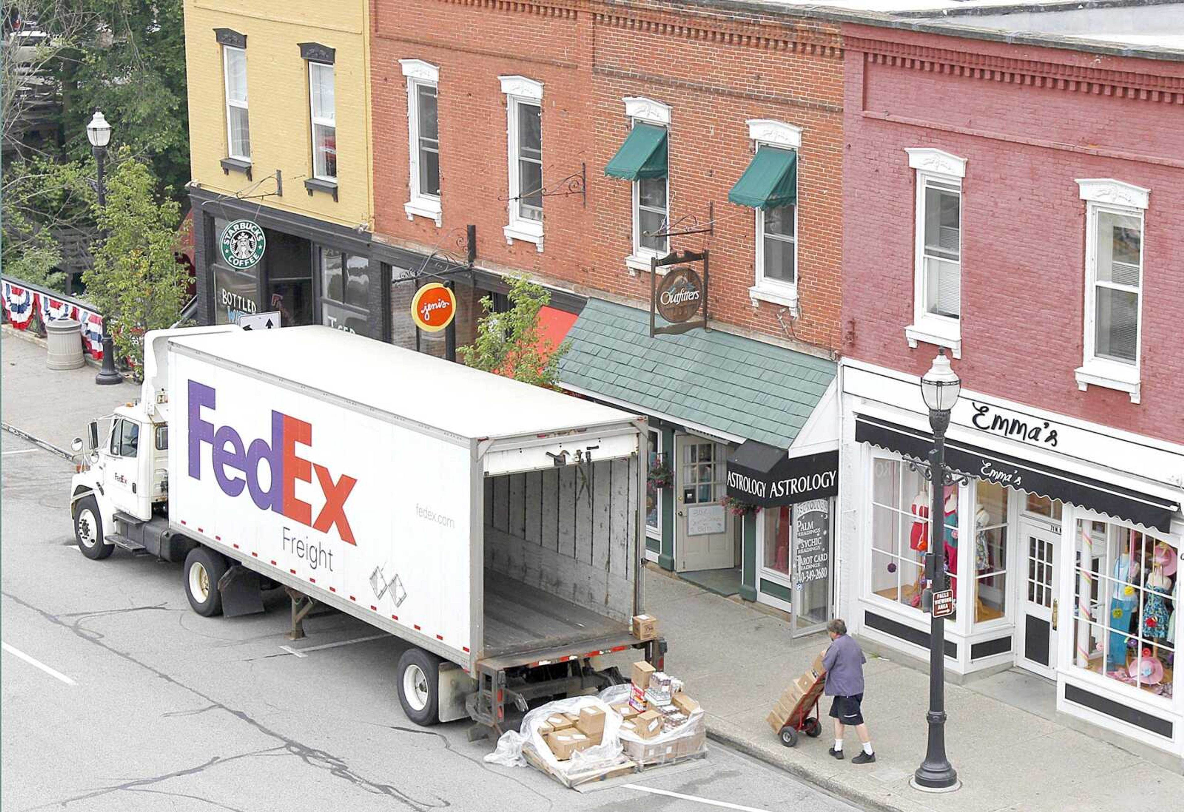 A Federal Express truck makes a delivery May 23 in downtown Chagrin Falls, Ohio. FedEx Corp. says the global economy is worsening and it&#8217;s cutting its forecast for the fiscal year ending in May. The world&#8217;s second largest package delivery company says profit in the current quarter will be well below year-ago results. (Associated Press file)