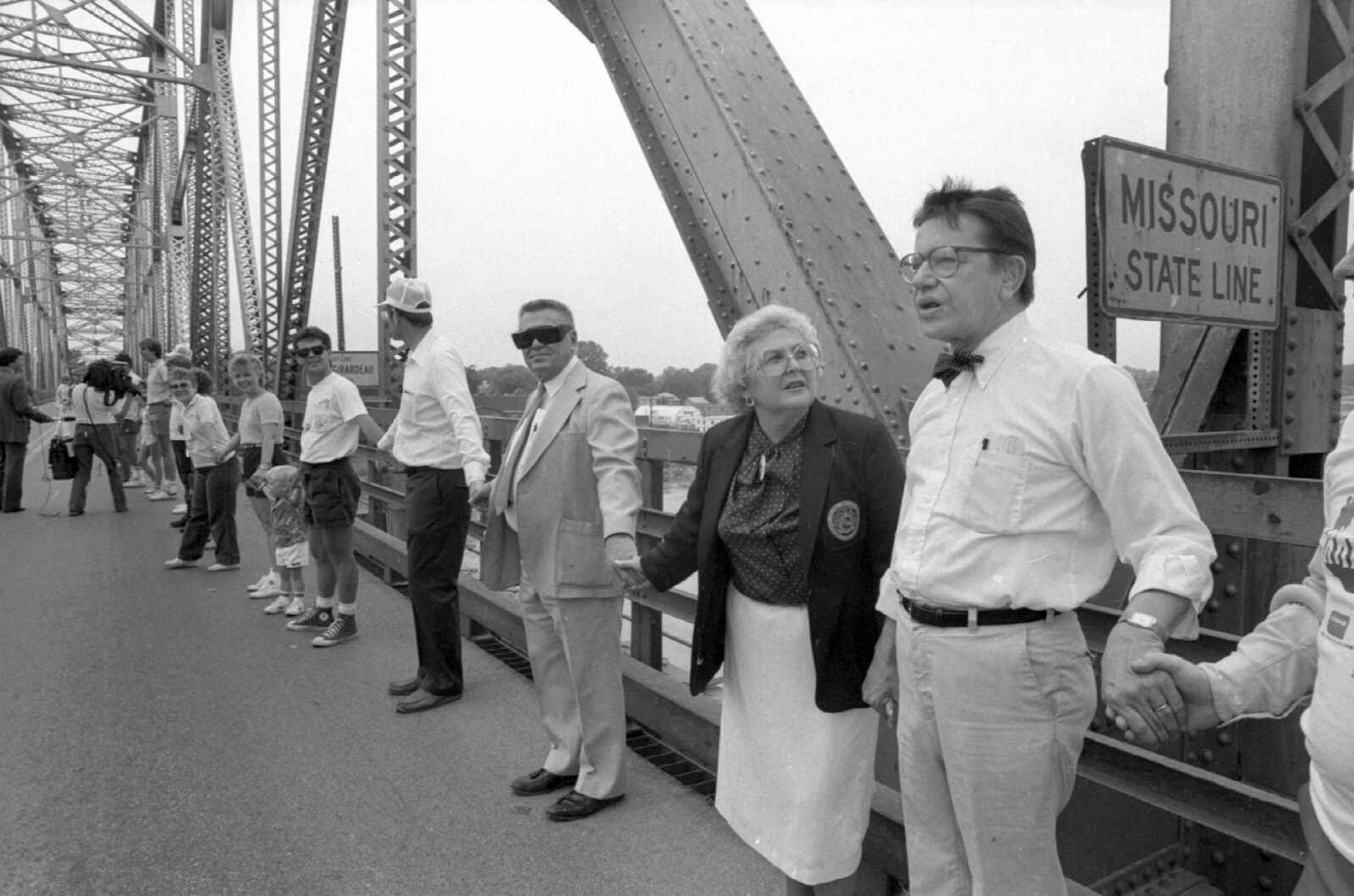 Published May 25, 1986
Missouri and Illinois were linked on the Mississippi River bridge Sunday as a part of "Hands Across America" activities. Here, Illinois Sen. Paul Simon, right, joins hands with Missouri State Rep. Mary Kasten at the Missouri-Illinois line on the bridge. Standing next to Mrs. Kasten is her husband, Dr. Melvin Kasten. (Missourian archive photo by Fred Lynch)