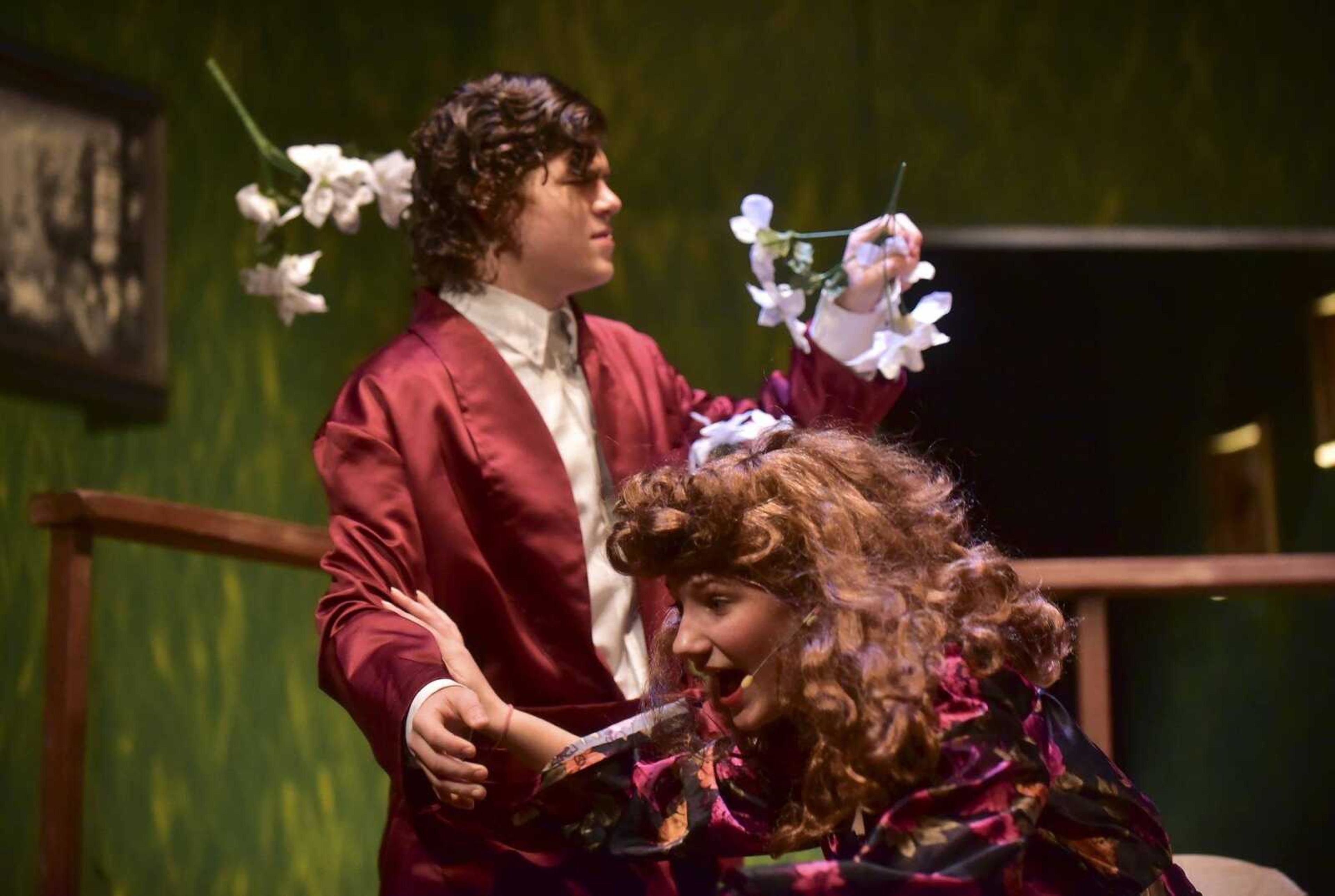 River Ketcherside as Charles Condomine and Jacqui Lang as Ruth Condomine cover their faces from flowers thrown by Morgan Green as Elvira during a dress rehearsal for the play "Blithe Spirit" at the Richard D. Kinder Performance Hall at Cape Girardeau Central High School.