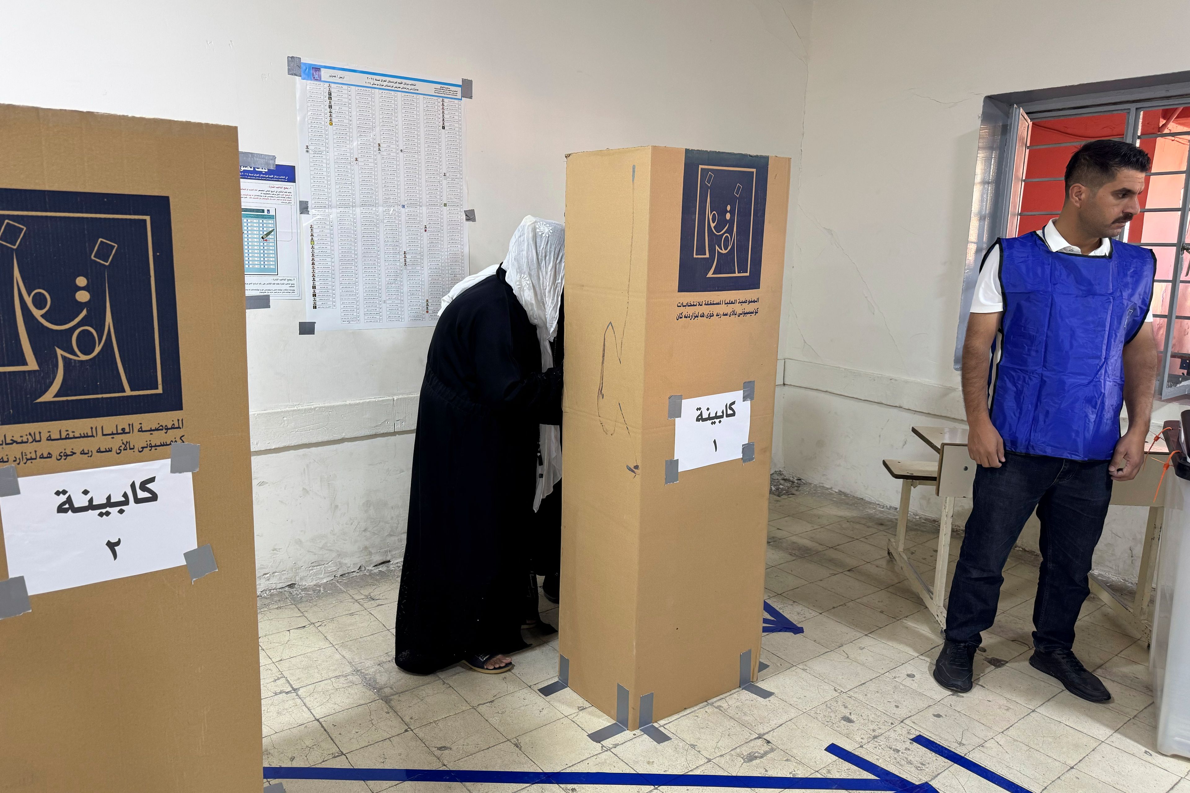 A woman enters a voting boot during parliamentary elections of Iraq’s semi-autonomous northern Kurdish region, in Irbil, Sunday, Oct. 20, 2024. (AP Photo/Salar Salim)