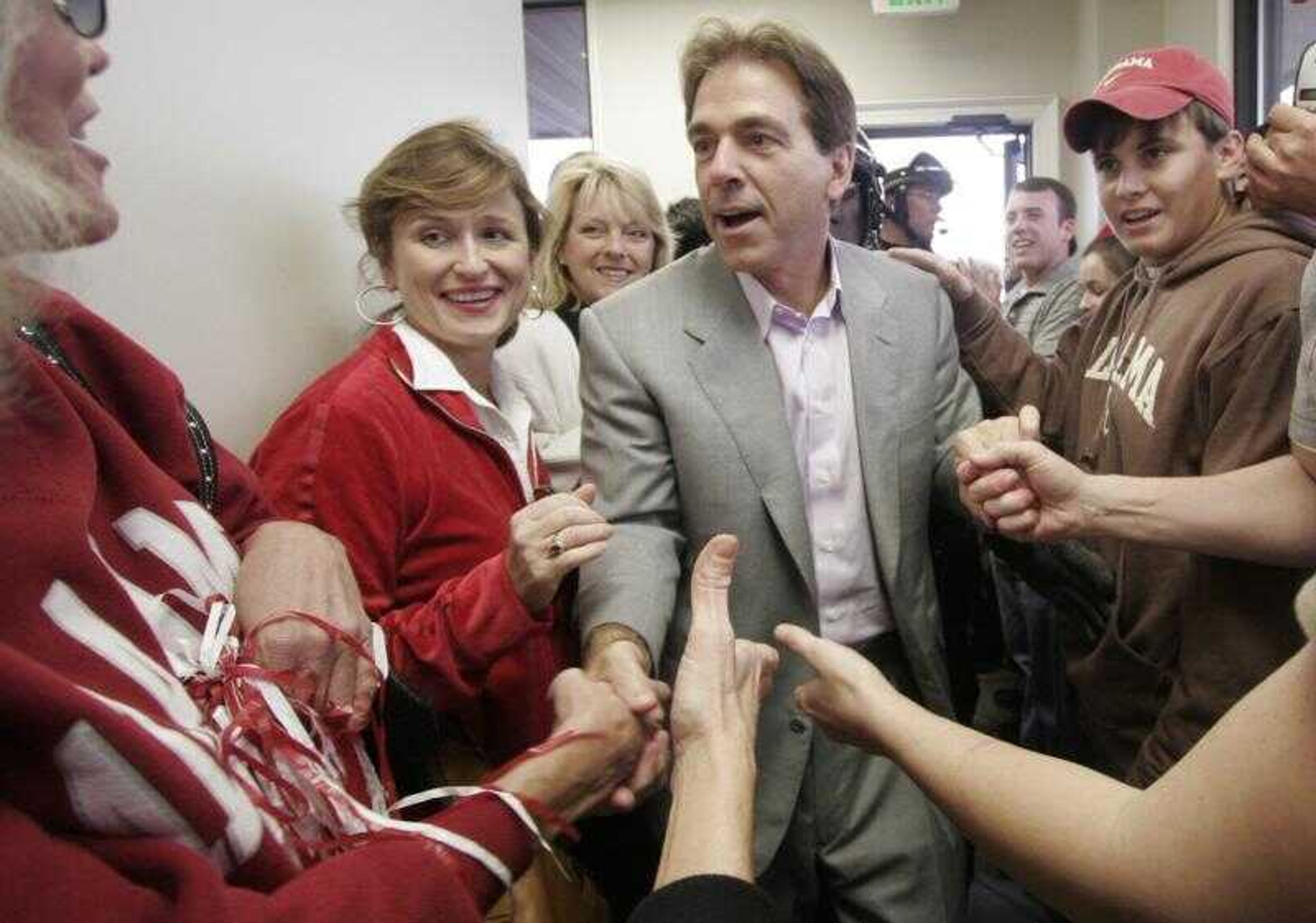 New Alabama football coach Nick Saban shook hands with fans after getting off a plane Wednesday in Tuscaloosa, Ala. Saban was lured away from the Miami Dolphins with a deal that will make him the highest-paid coach in college football. (MICHELLE WILLIAMS ~ Associated Press)