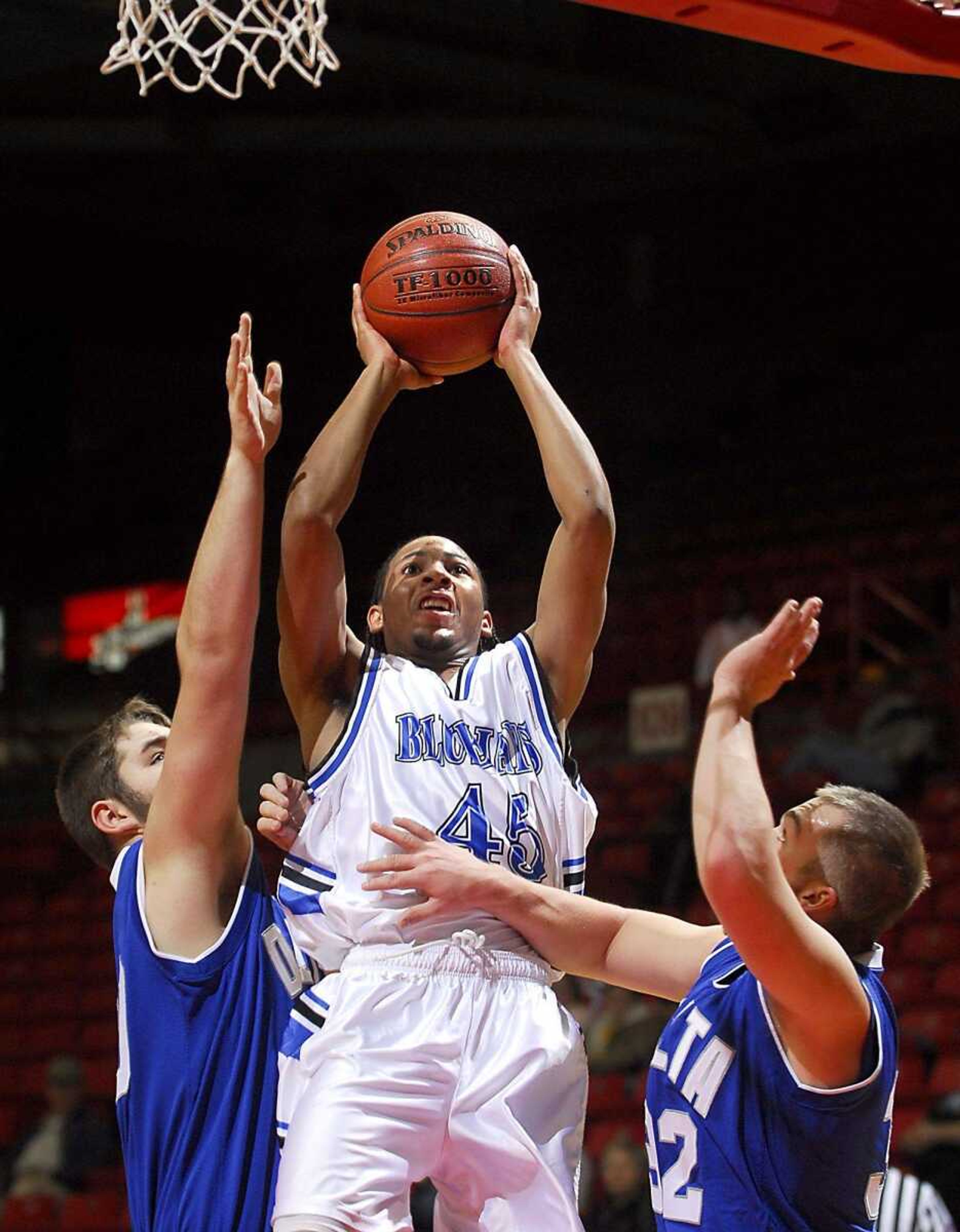 Charleston's Donald Dixon took a shot over Delta's Gage Bowers, left, and Chase Rhodes in the first quarter of the opening game in the Southeast Missourian Christmas Tournament on Wednesday at the Show Me Center. (Fred Lynch)