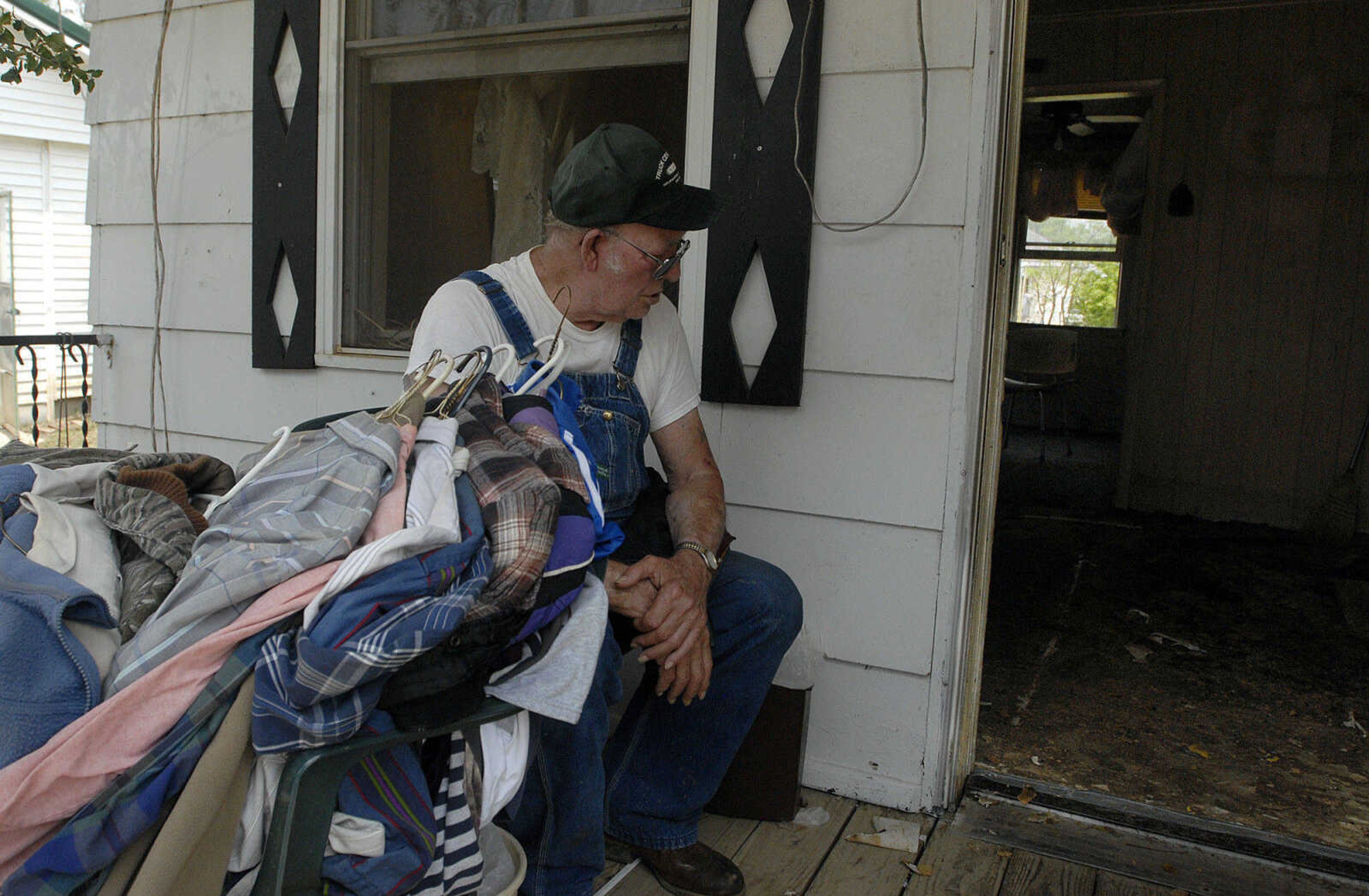 LAURA SIMON~lsimon@semissourian.com
David E. Jordan sits on the porch of his Boone Street home Wednesday, May 11, 2011 in Morehouse. Jordan has lived in Morehouse for 35 years, and was able to salvage some clothing from his home that was filled with floodwater.