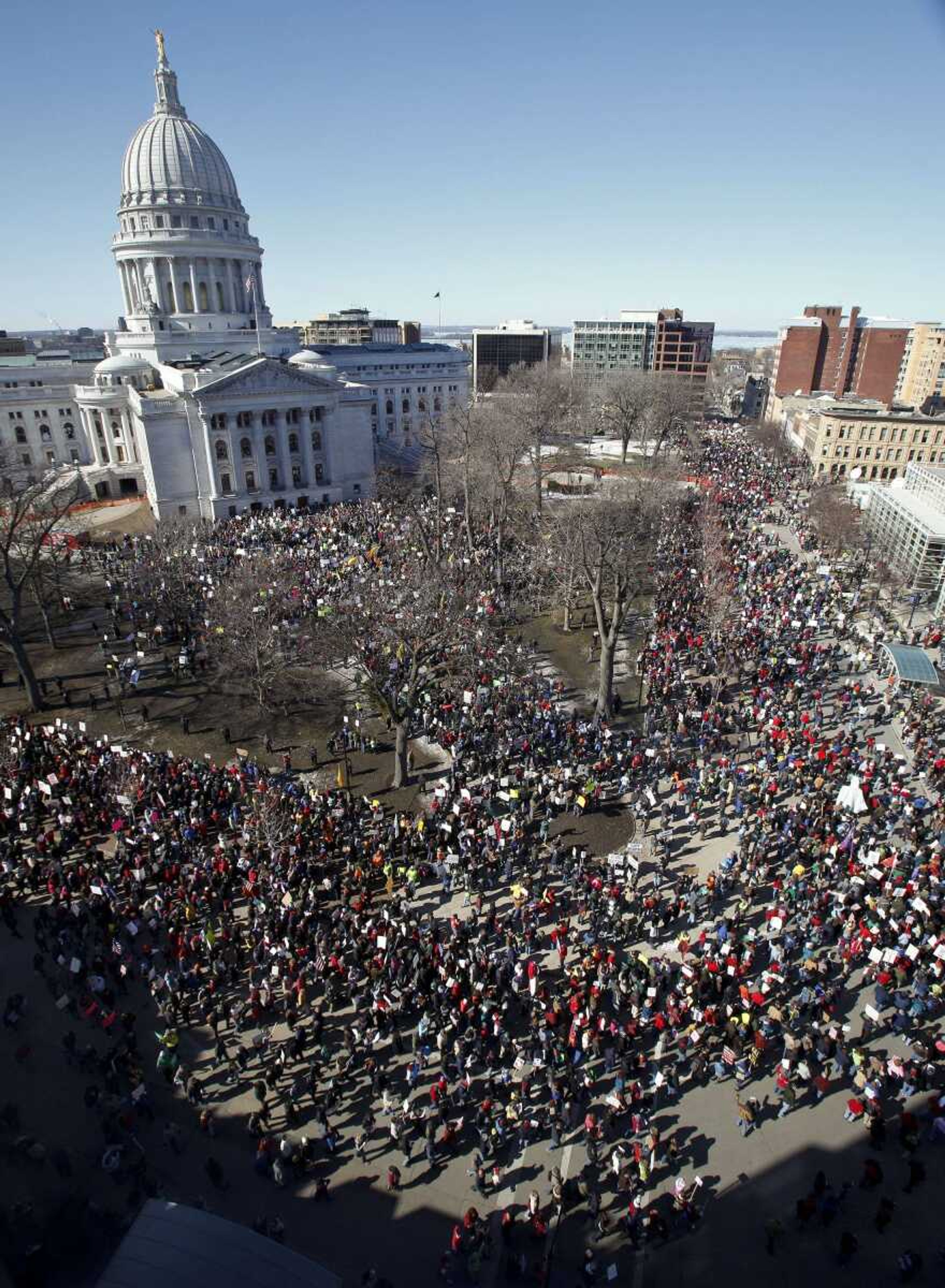 Protesters gather Saturday outside the state Capitol in Madison, Wis. A few dozen police officers stood between supporters of Republican Gov. Scott Walker on the muddy east lawn of the Capitol and the much larger group of pro-labor demonstrators who surrounded them.(Andy Manis ~ Associated Press)