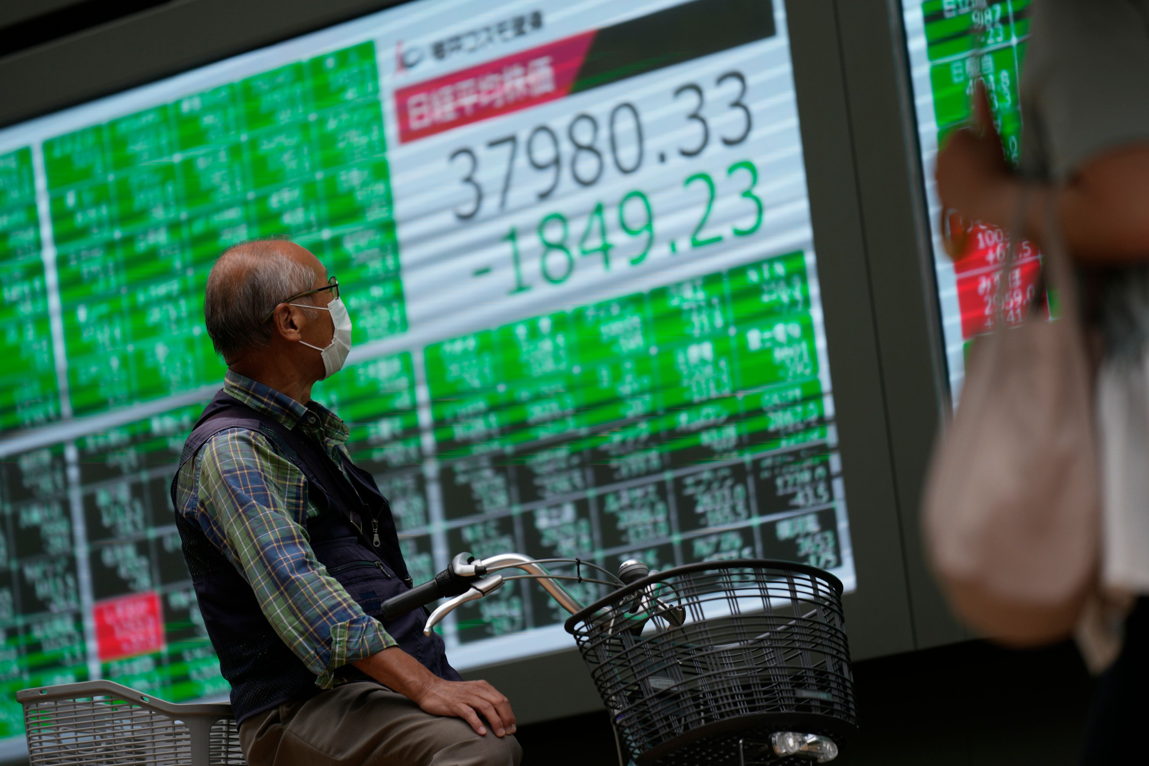 A man looks at monitors showing Japan's Nikkei 225 index at a securities firm in Tokyo, Monday, Sept. 30, 2024. (AP Photo/Hiro Komae)