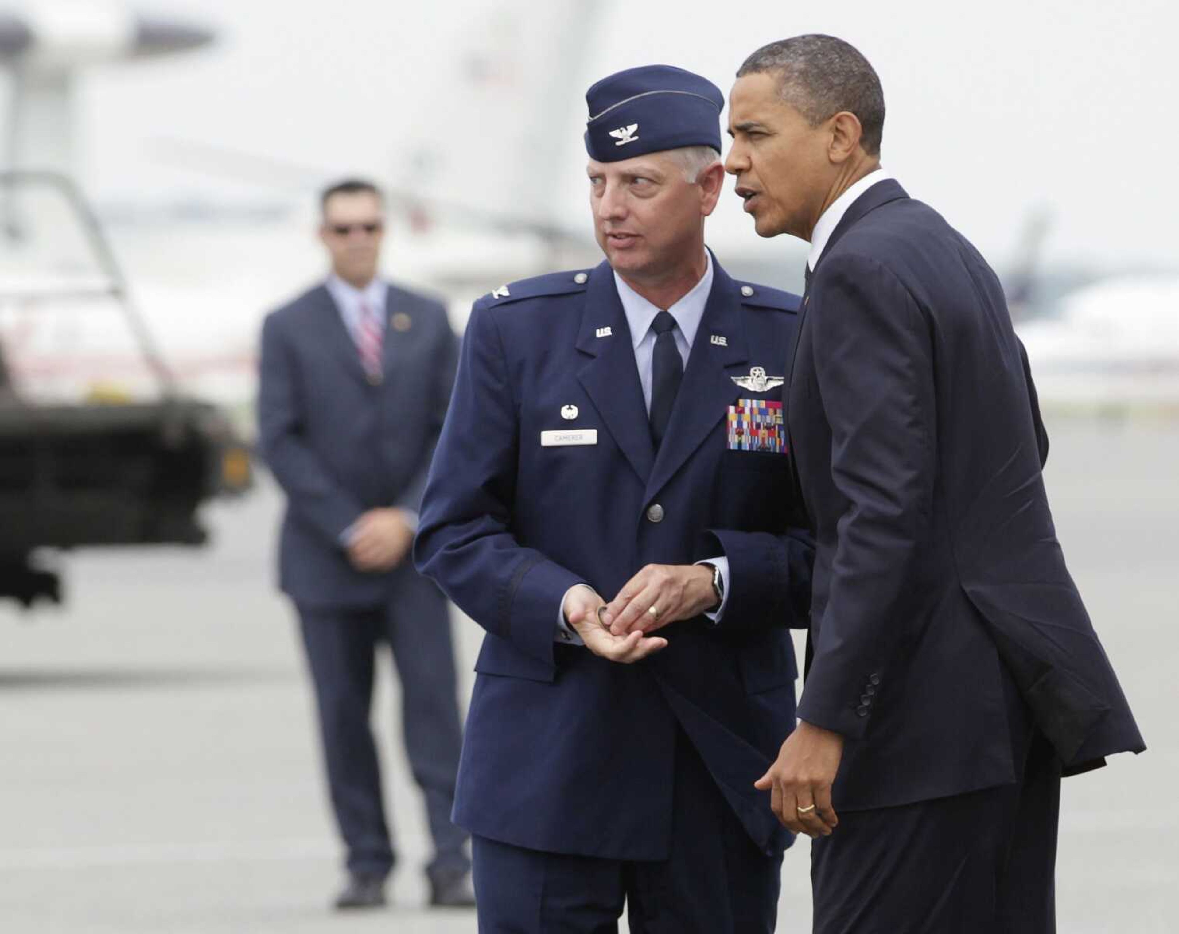 President Barack Obama is greeted Tuesday by Col. Mark Camerer, the 436th Airlift Wing Commander upon his arrival at Dover Air Force Base, Del. The President met privately with families of thirty Americans killed in an International Security Assistance Force helicopter crash in eastern Afghanistan while supporting Operation Enduring Freedom. (Carolyn Kaster ~ Associated Press)