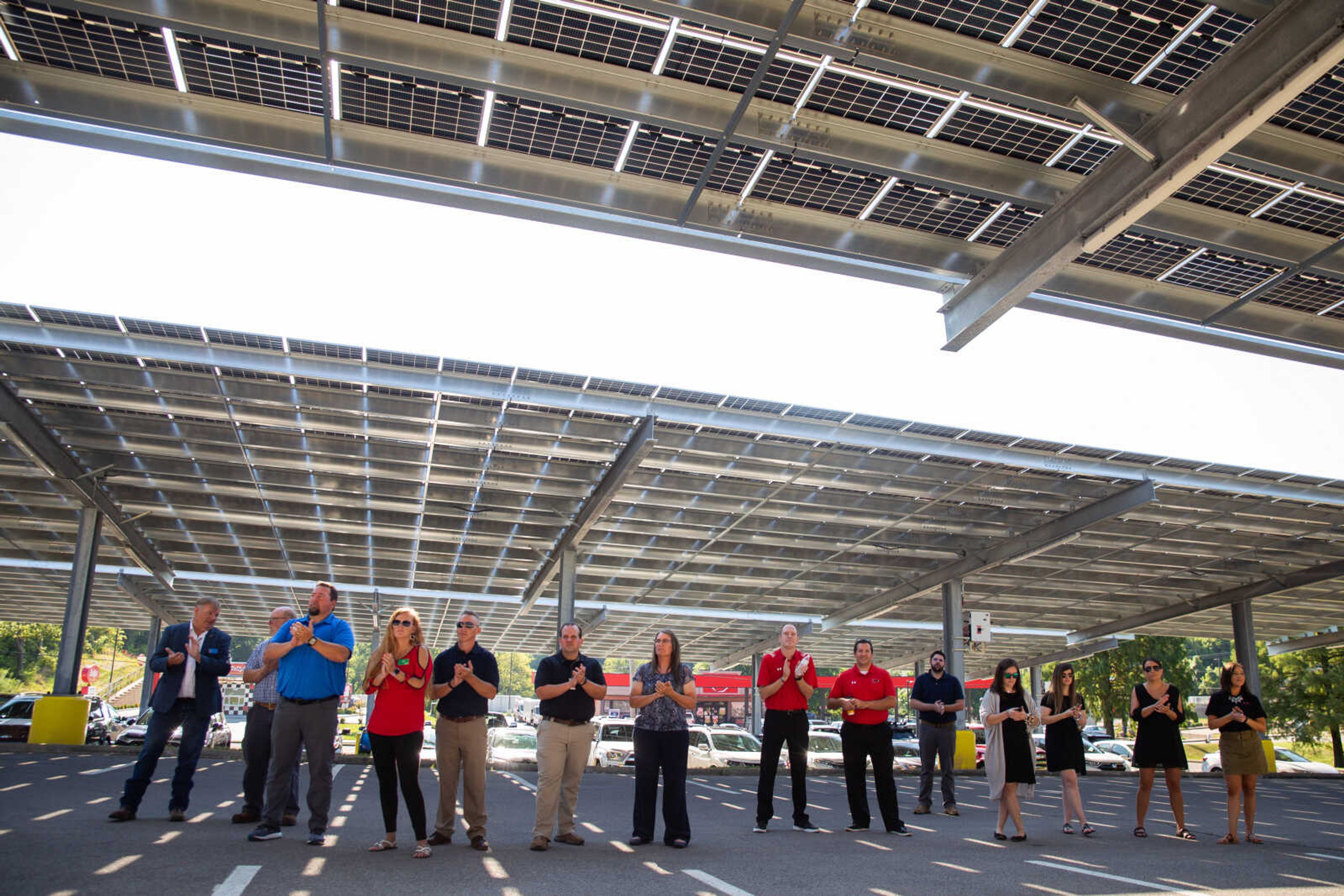 SEMO faculty and staff gather in the shade under a canopy of parking lot solar panels on campus on Thursday, Aug. 25.