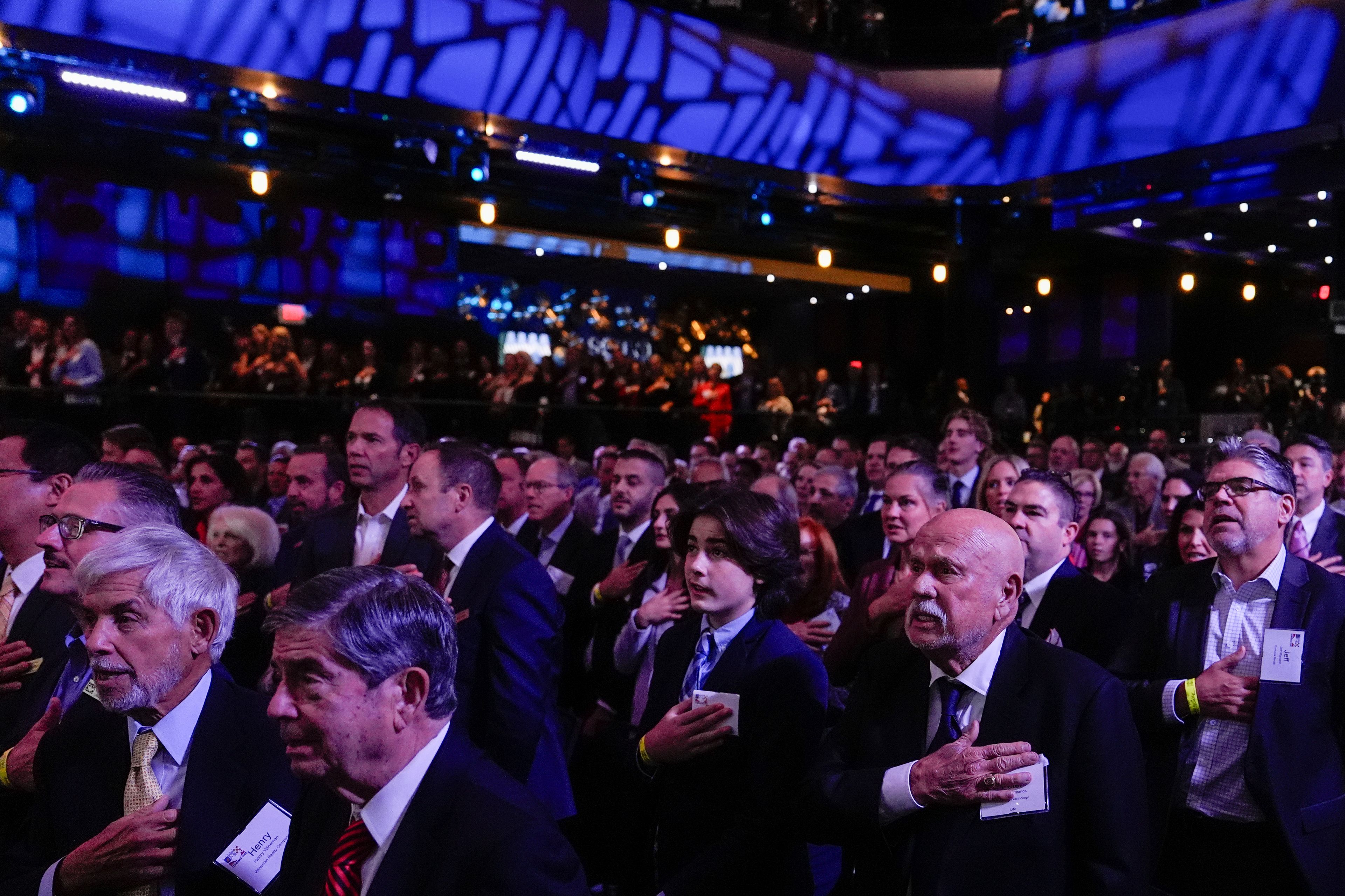 Members of the Detroit Economic Club stand for the pledge of allegiance prior to a speech by Republican presidential nominee former President Donald Trump, Thursday, Oct. 10, 2024, in Detroit. (AP Photo/Julia Demaree Nikhinson)