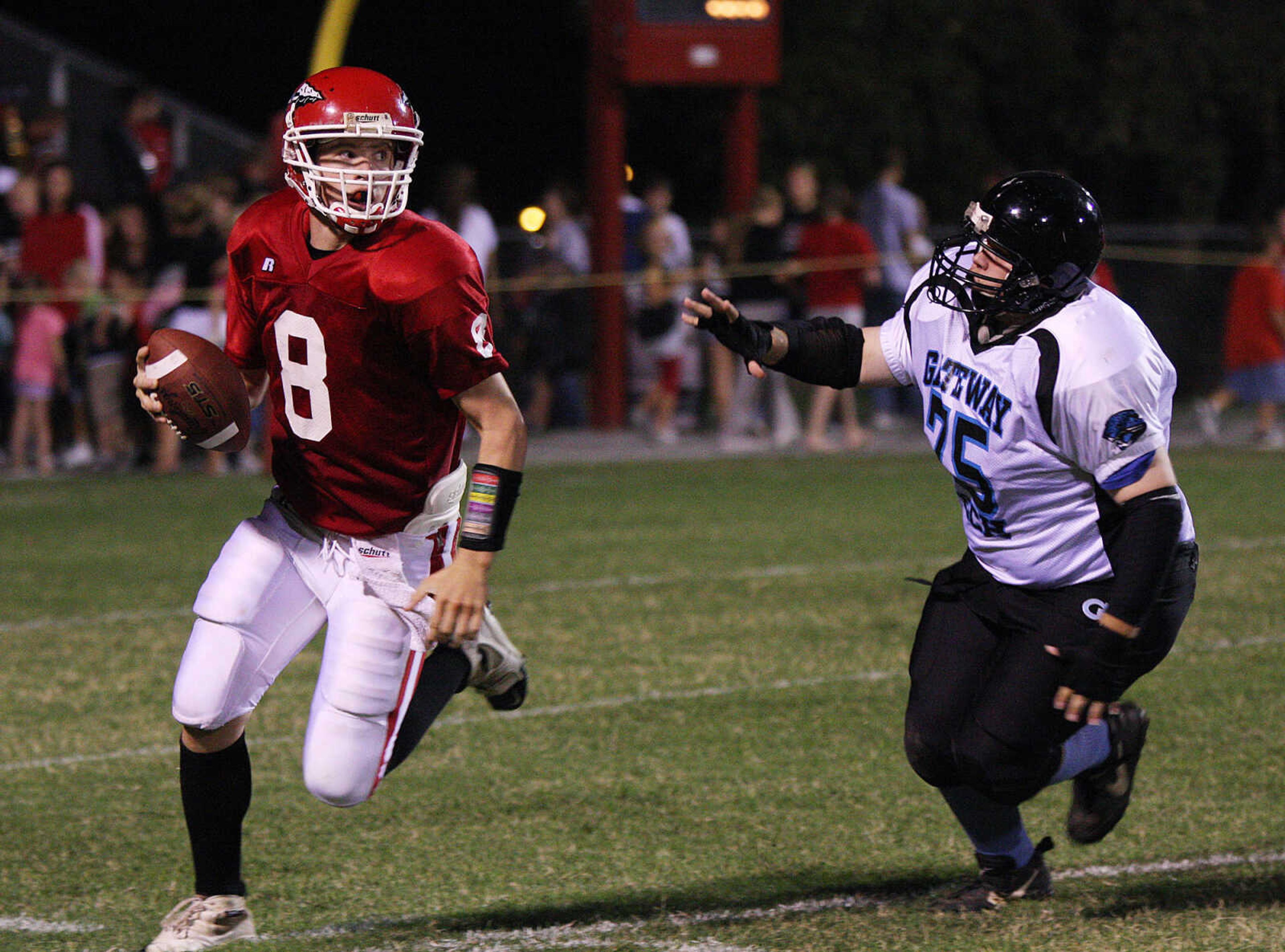 Jackson quarterback Bobby Clark, left, is forced into running the ball.