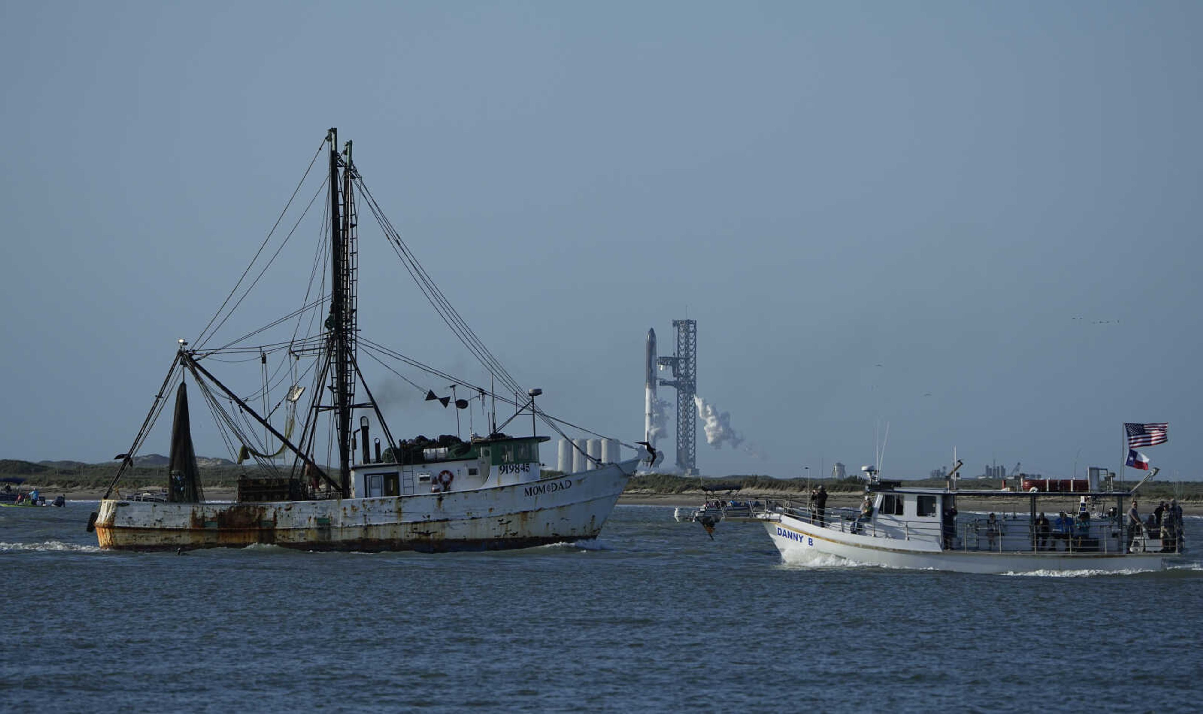 Boaters pass SpaceX's Starship in Boca Chica, Texas, Monday, April 17, 2023. SpaceX called off its first launch attempt of its giant rocket Monday after a problem cropped up during fueling. (AP Photo/Eric Gay)