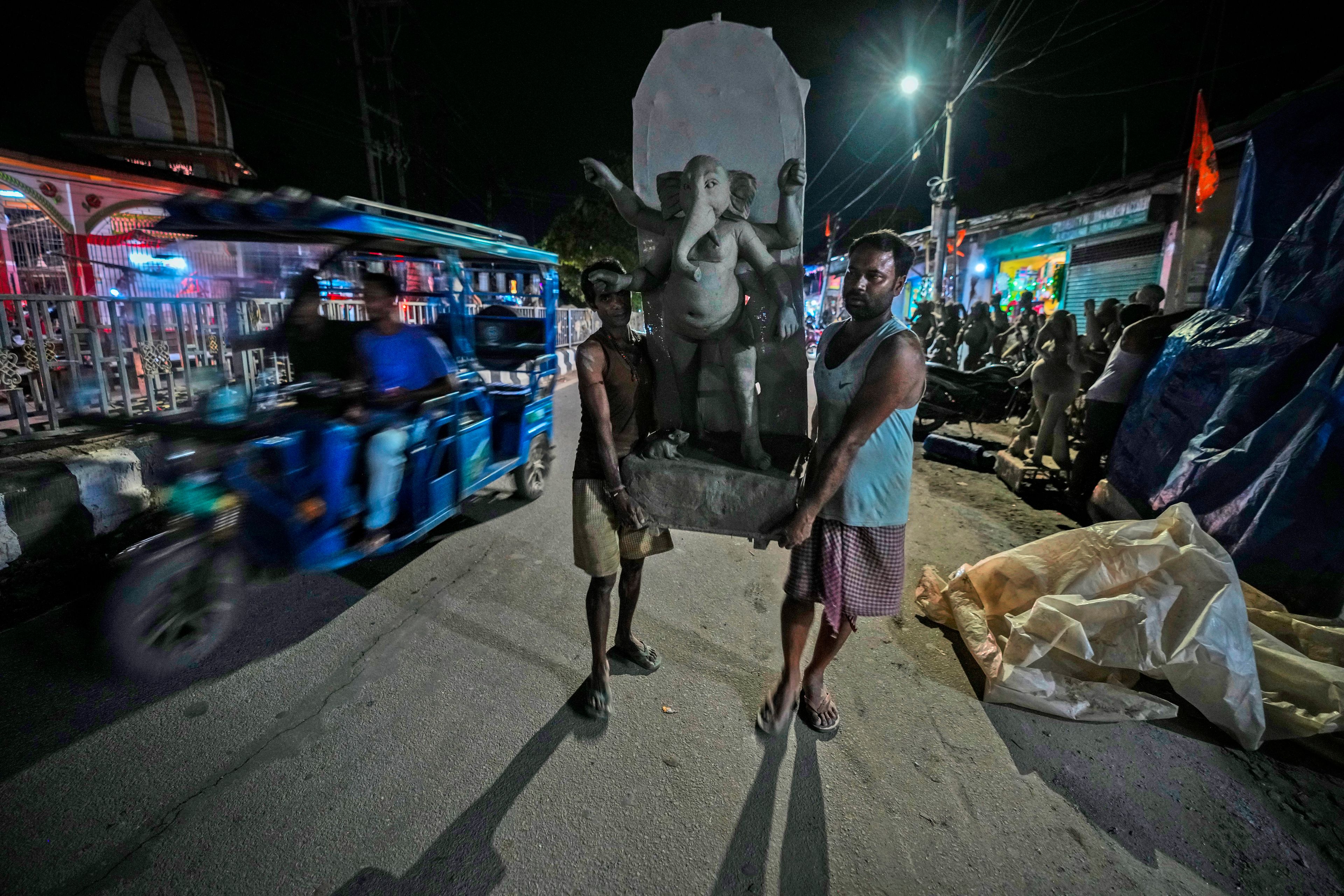 Artisans carry a mud idol of the Hindu god Ganesha outside a workshop ahead of the Durga Puja festival in Guwahati, India, Wednesday, Oct. 2, 2024. (AP Photo/Anupam Nath)