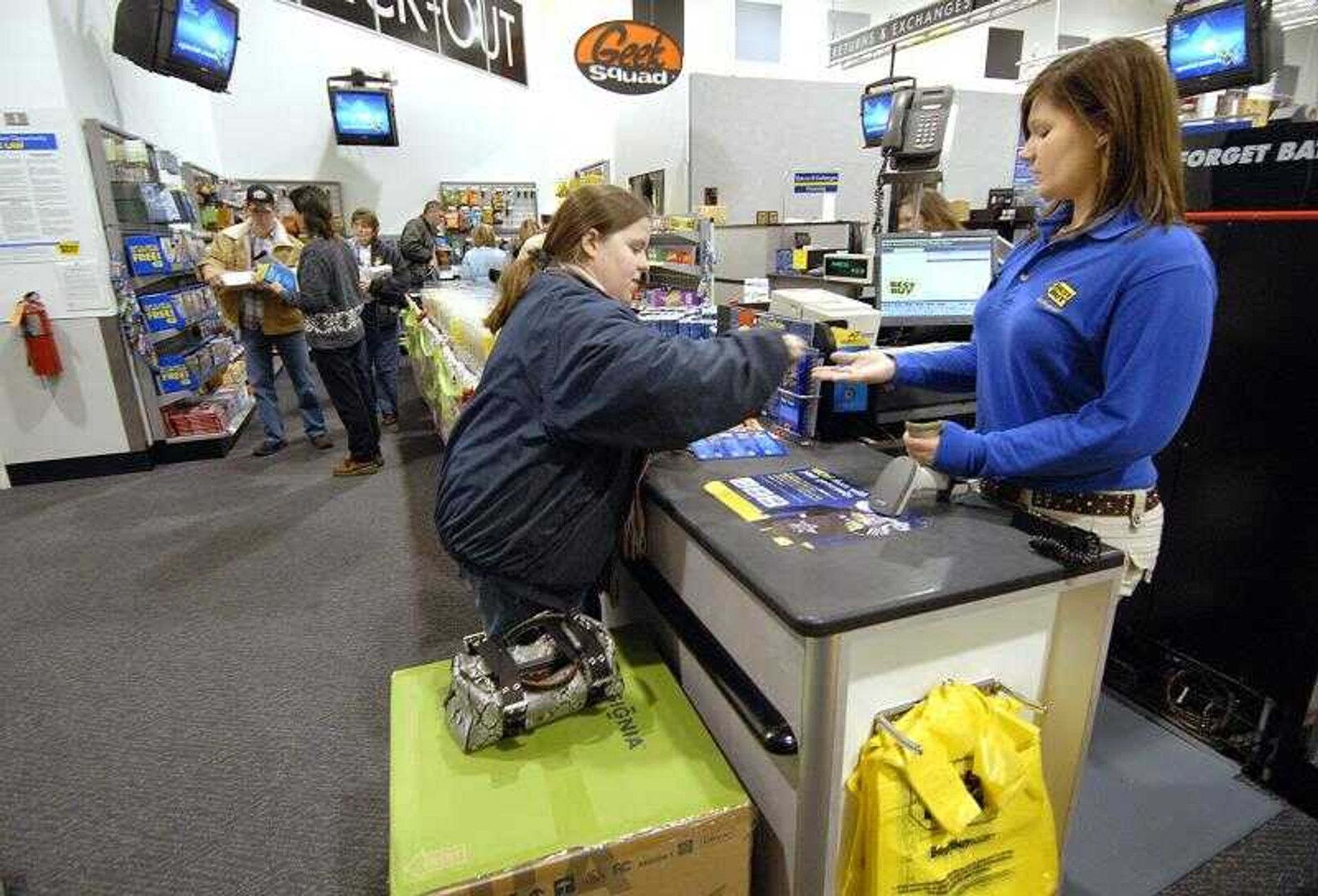 Ashley Stevens, center, of Cape Girardeau paid Best Buy cashier Mindy Hendrix, right, for her purchase as other customers wait their turn to check out on Black Friday in November. (Don Frazier)