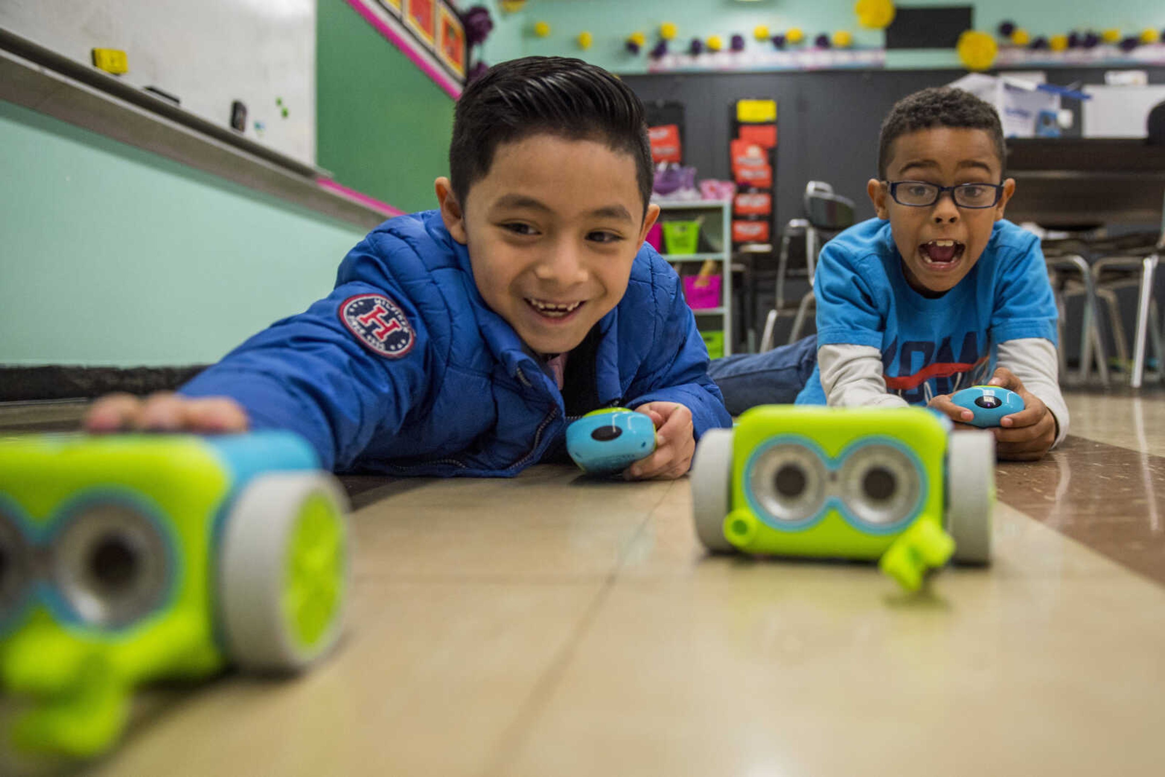 Christopher Fabian, 7, left, and Gavin Wyatt, 8, pilot toy robots around a classroom floor during a coding class at Jefferson Elementary in Cape Girardeau Friday, Dec. 21, 2018.