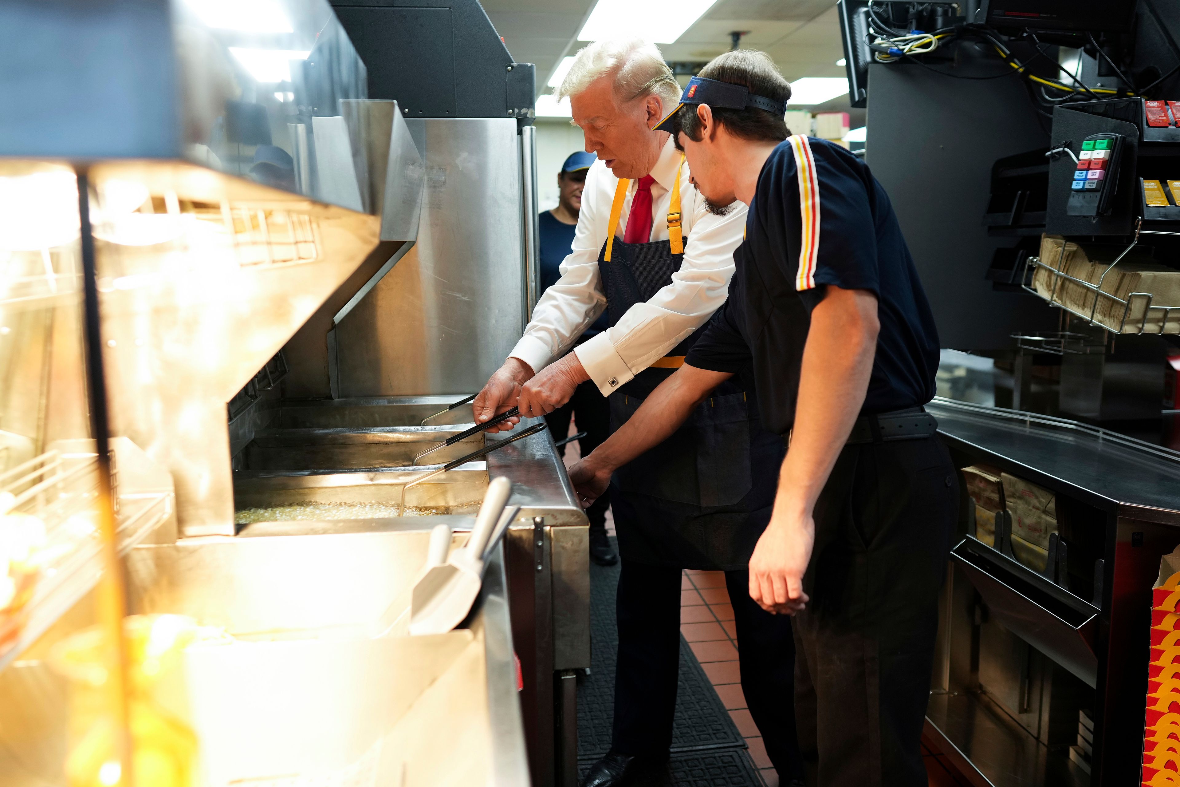 Republican presidential nominee former President Donald Trump, left, uses a frier alongside an employee during a visit to McDonald's in Feasterville-Trevose, Pa., Sunday, Oct. 20, 2024. (Doug Mills/The New York Times via AP, Pool)