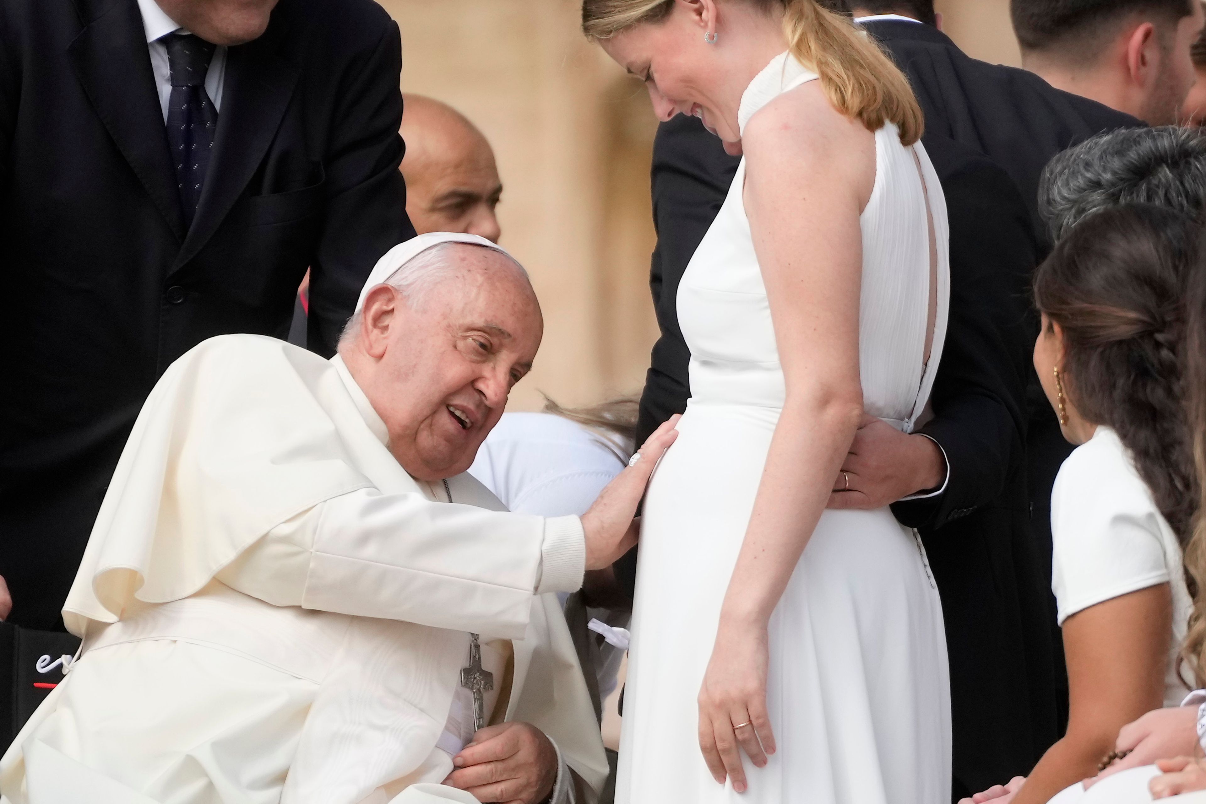 Pope Francis touches the belly of a newly married woman during his weekly general audience in St. Peter's Square, at the Vatican, Wednesday, Sept. 25, 2024. (AP Photo/Gregorio Borgia)