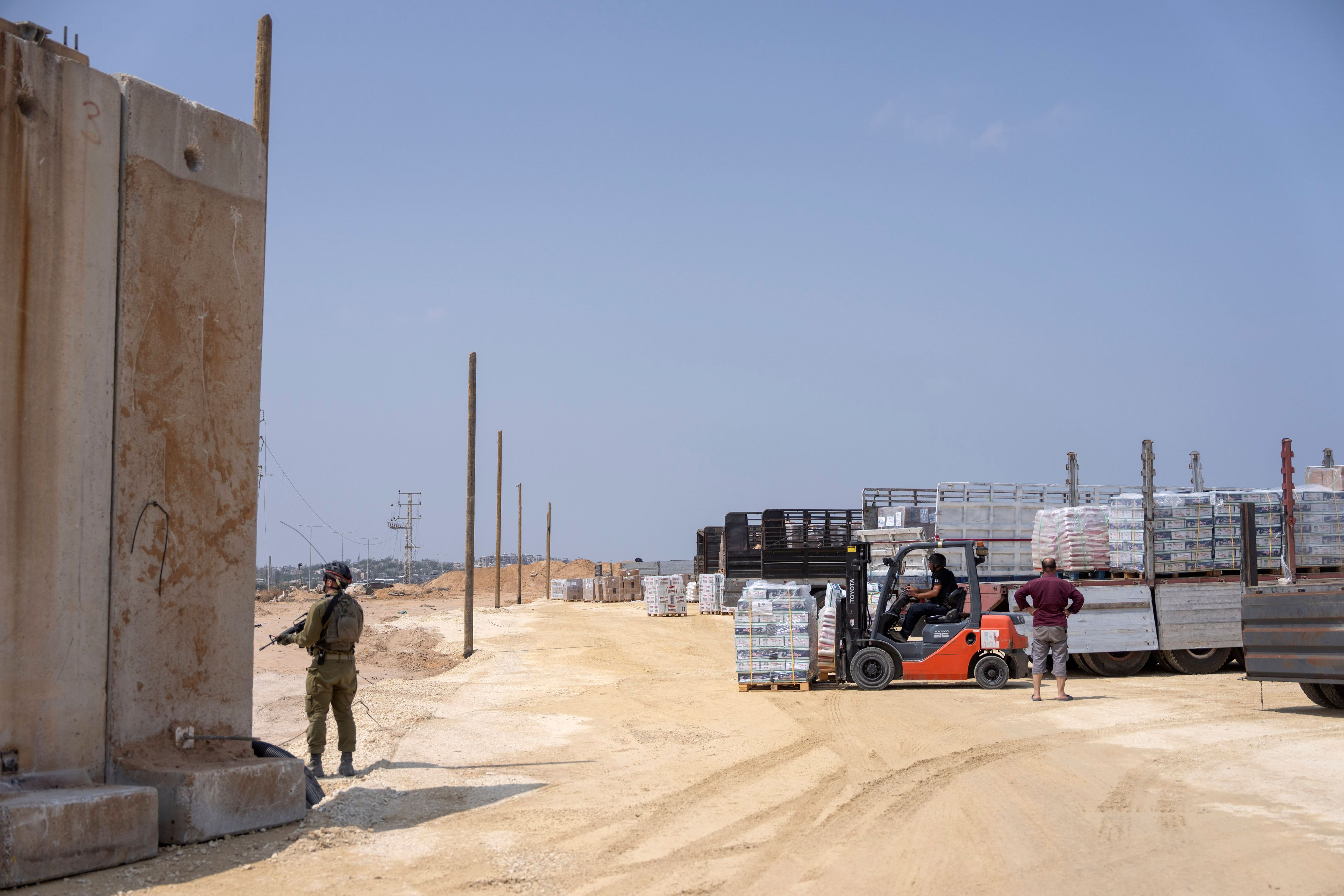 FILE - An Israeli soldier stands guard near trucks carrying humanitarian aid supplies bound for the Gaza Strip on the Palestinian side of the Erez crossing between southern Israel and northern Gaza, on May 1, 2024. (AP Photo/Ohad Zwigenberg, File)