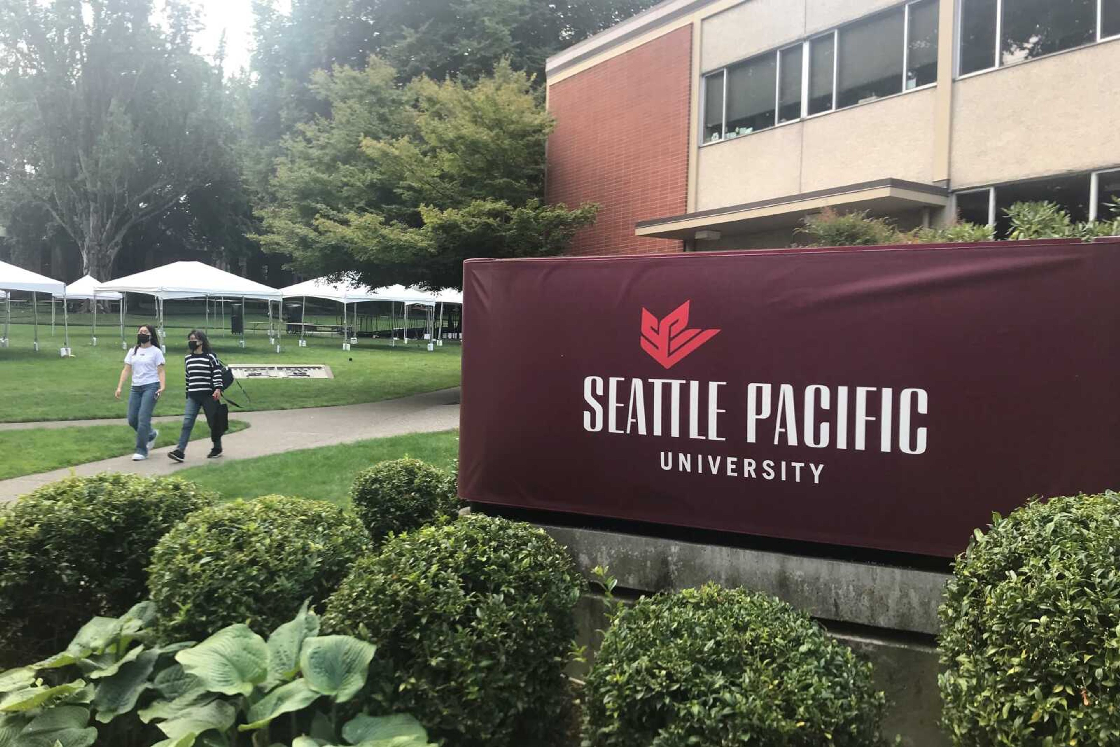 Students walk on the campus of Seattle Pacific University on Sunday in Seattle. A group of students, faculty and staff at the Christian university have sued leaders of the Board of Trustees for refusing to scrap an employment policy barring people in same-sex relationships from full-time jobs at SPU.