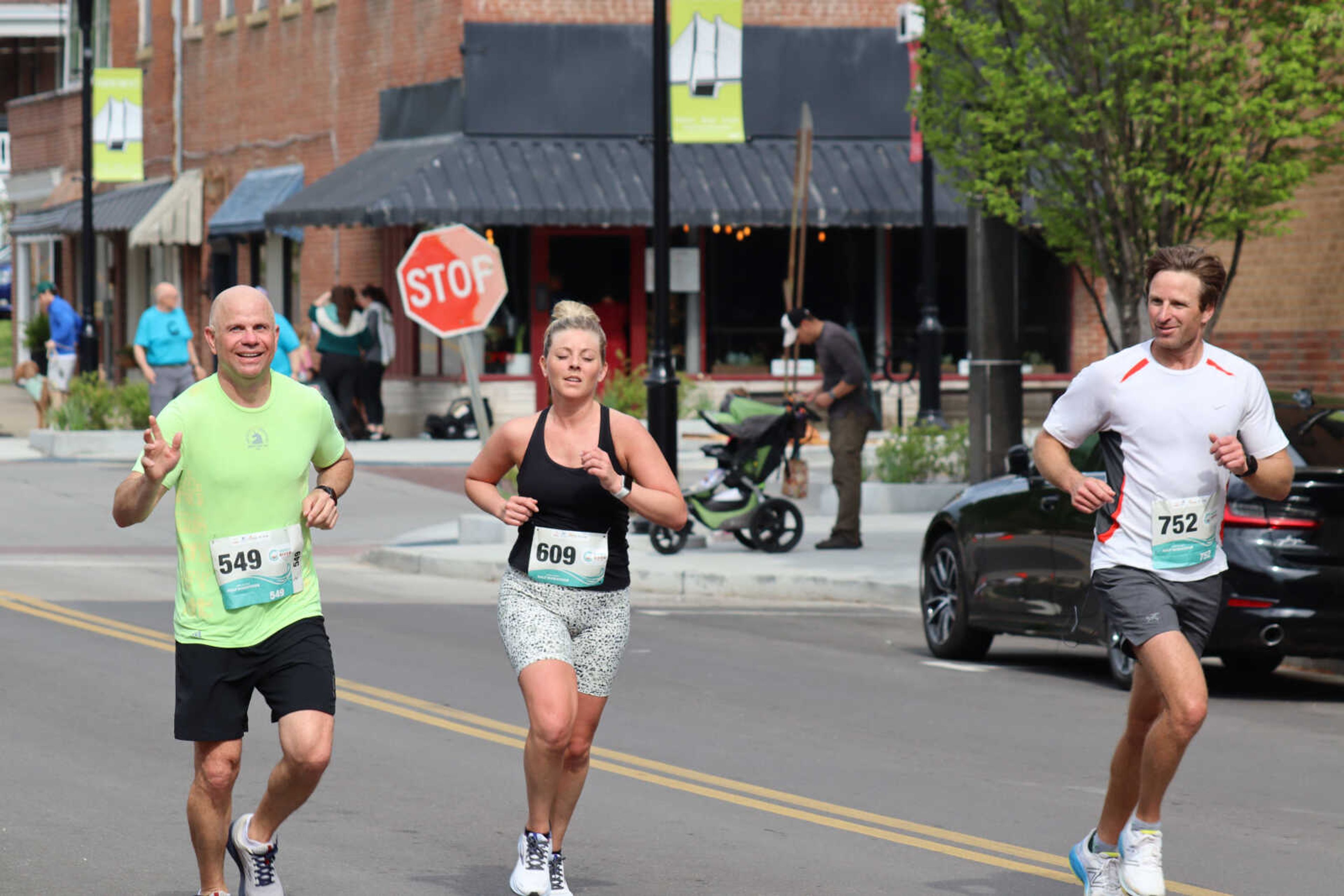 (Left to right) Kevin Dorris, Alexa Kelpe and Matt Vollink smiling at the onlookers while makibng it to the finish line.