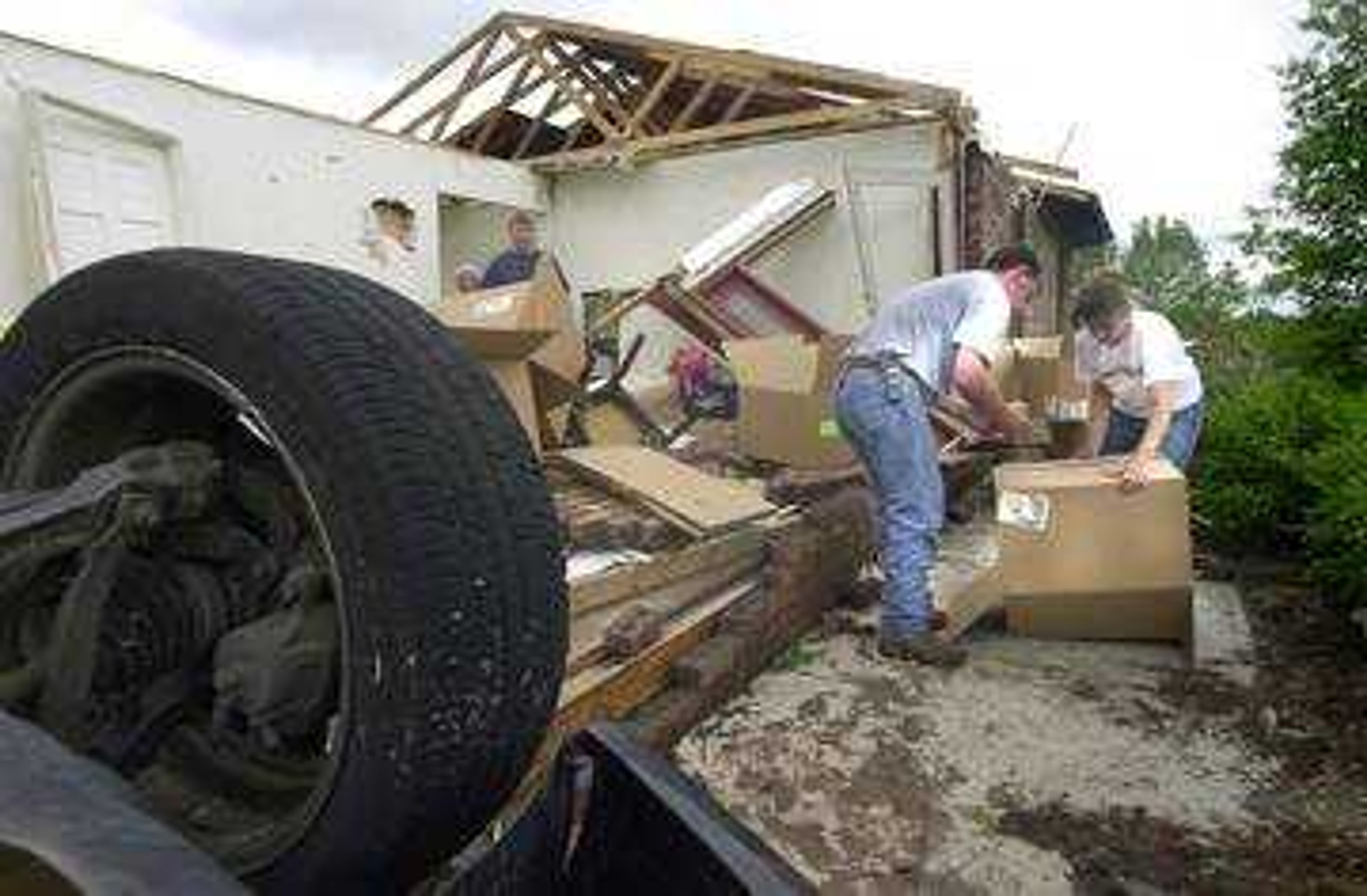 Ted Haertling and Cindy Kertz, right of Perryville, arrived at their Calie Wilson's house at 1217 Lakewoods Drive around 10 a.m. to help with clearing the debris.  A black car was tossed into the brick house.  Wilson, with husband Paul and 11 year old son Chaz, had just moved to this location last week and was able to escape unharmed to the basement with around 15 seconds to spare.