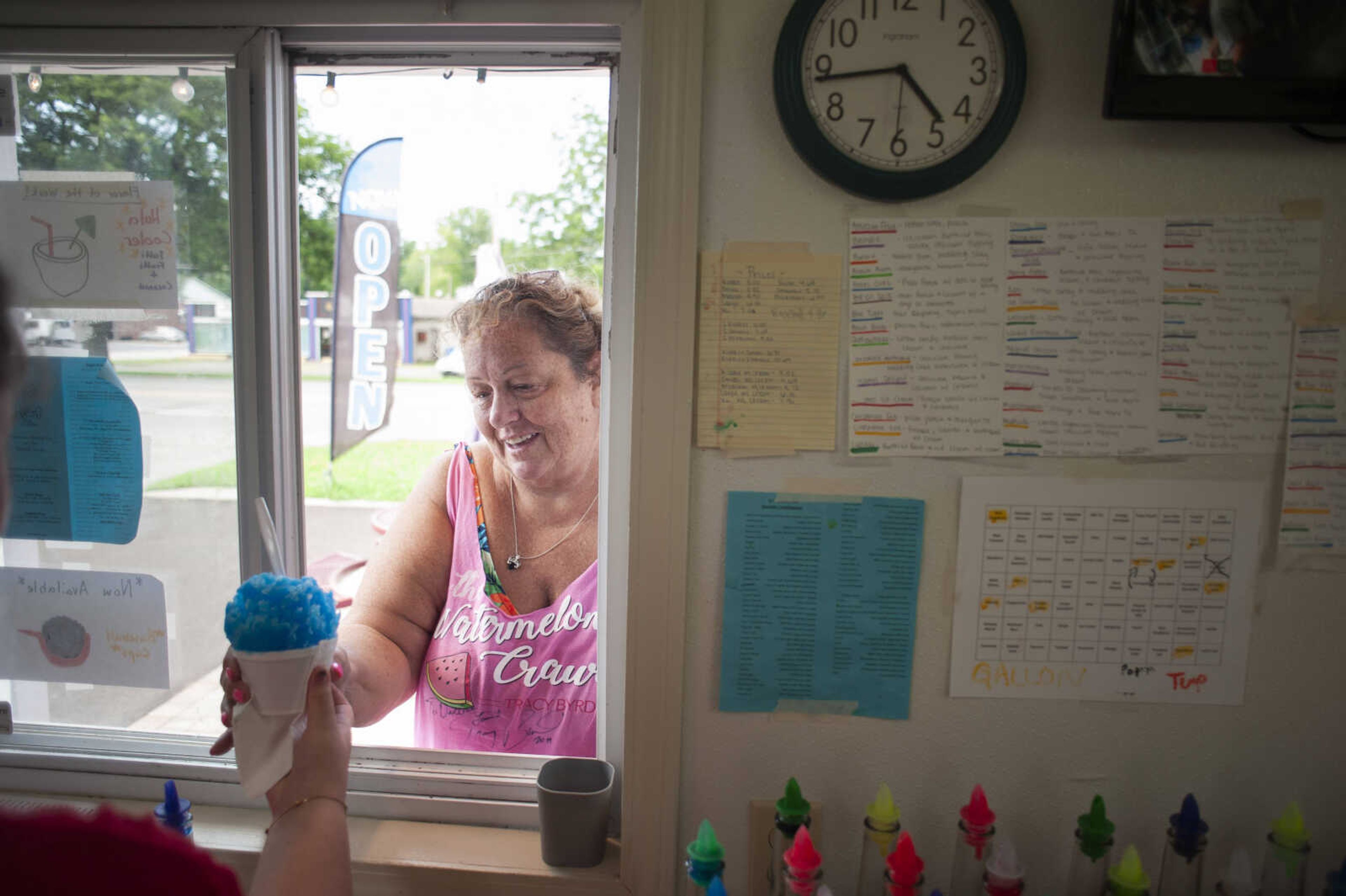 Debbie Kays of Cape Girardeau receives her order of a blue raspberry shaved ice Thursday, July 18, 2019, at Ty's Summer Sno in Cape Girardeau.