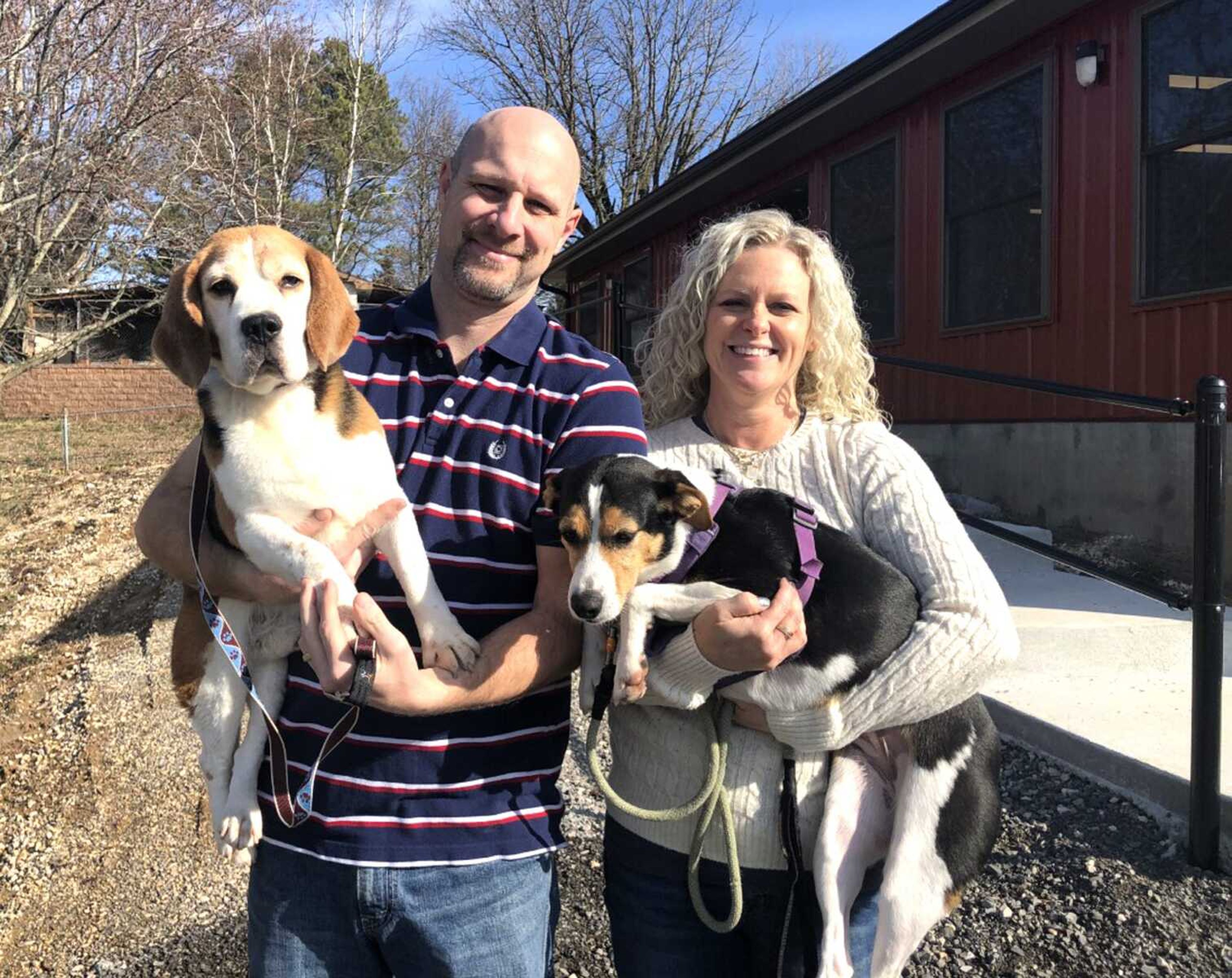 Stacy Busch-Heisserer and her husband, Chris Heisserer, stand in front of the new Busch's Kennel offices Feb. 27, while holding two of their dogs, Luke, left, and Elsa.