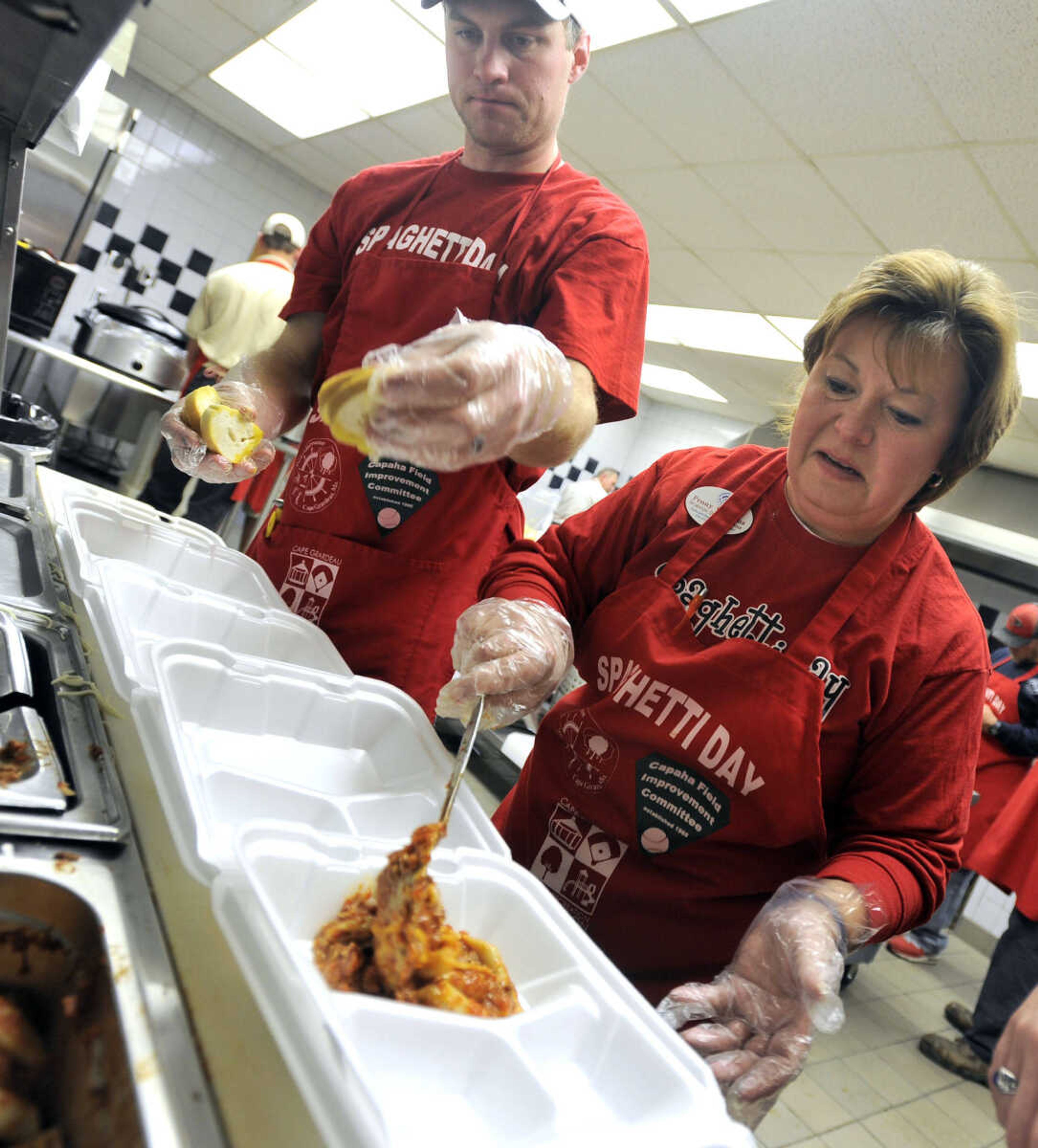 Penny Williams and Brian Schlichting prepare carryouts at the Parks & Recreation Foundation Spaghetti Day Wednesday, Nov. 13, 2013 at the Arena Building.