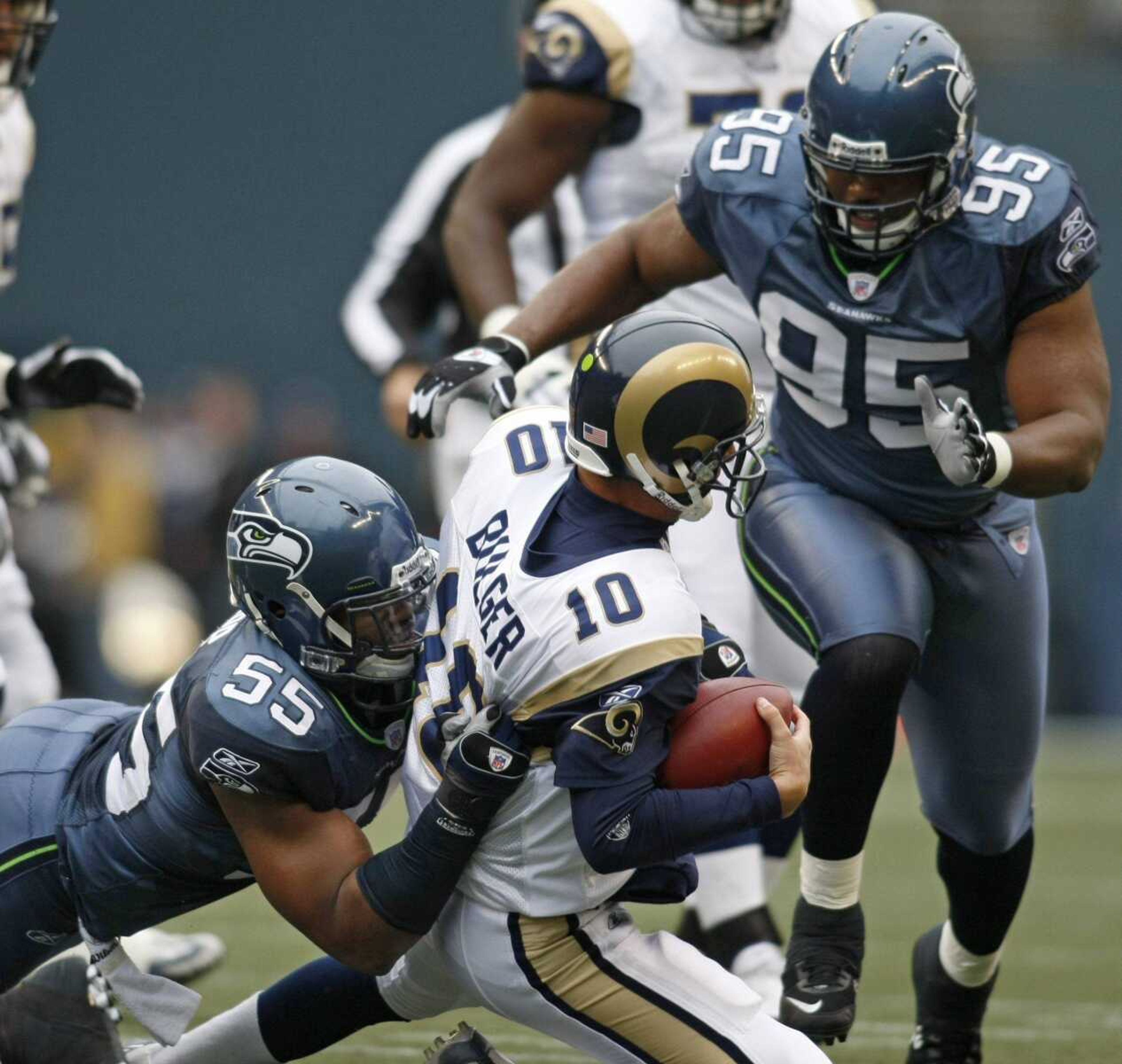 Seahawks defensive end Darryl Tapp sacked Rams quarterback Marc Bulger as teammate Ellis Wyms closed in on the play during the first half Sunday in Seattle. Bulger was sacked seven times in the game. (JOHN FROSCHAUER ~ Associated Press)