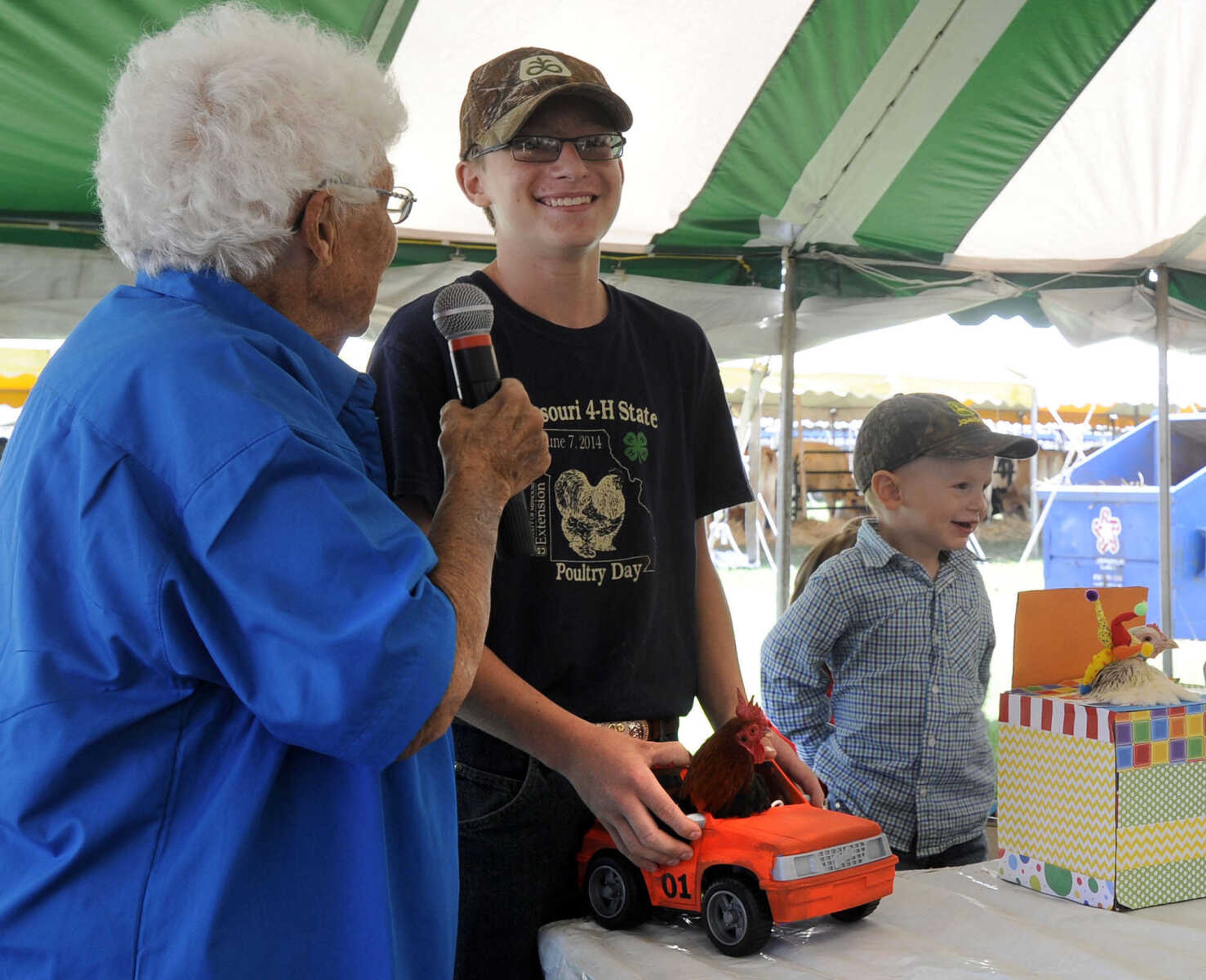 Dortha Strack interviews Steven Peters who entered his "Rooster of Hazzard" in the poultry dress-up contest Sunday, Sept. 7, 2014 at the SEMO District Fair.