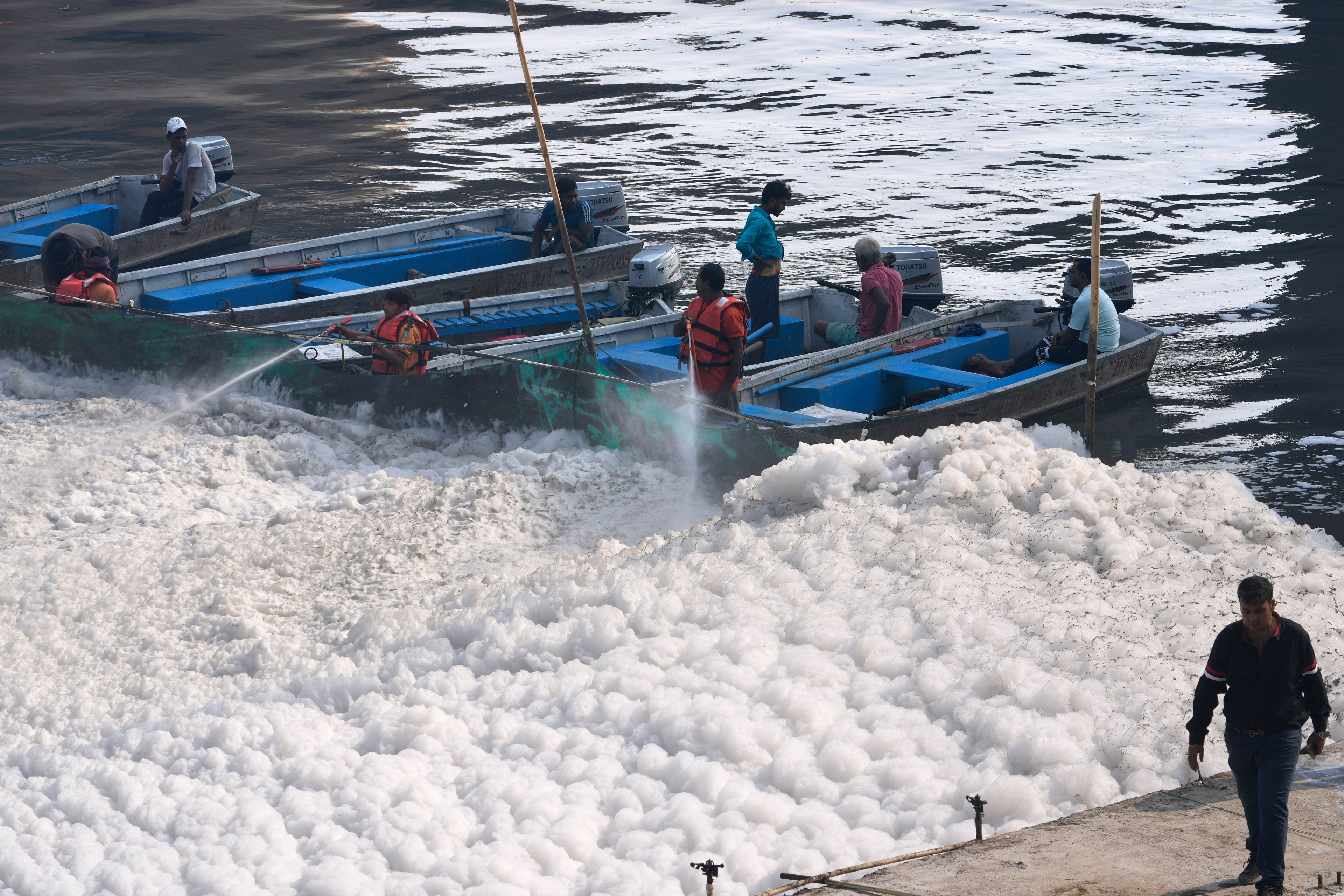 Workers for the Delhi Jal or water board spray chemical to clean the toxic foams in the river Yamuna in New Delhi, India, Tuesday, Oct. 29, 2024. (AP Photo/Manish Swarup)