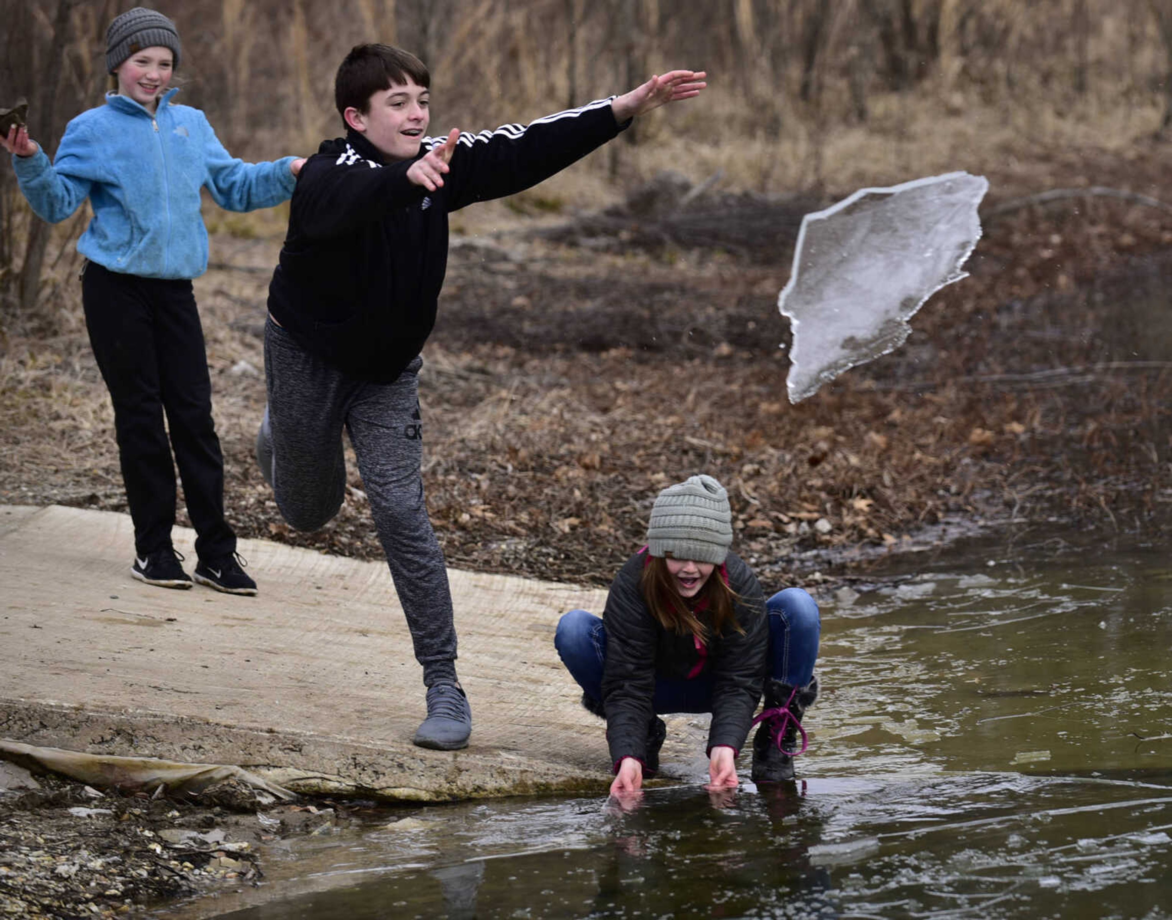 Drew Nugent, 14, throws a chunk of ice at a frozen section of Lake Boutin while playing with Melanie Nugent, 10, and Emmy Gross, 10, left, before the Polar Plunge benefit for Special Olympics Missouri on Saturday, Feb. 3, 2018, at Trail of Tears State Park.