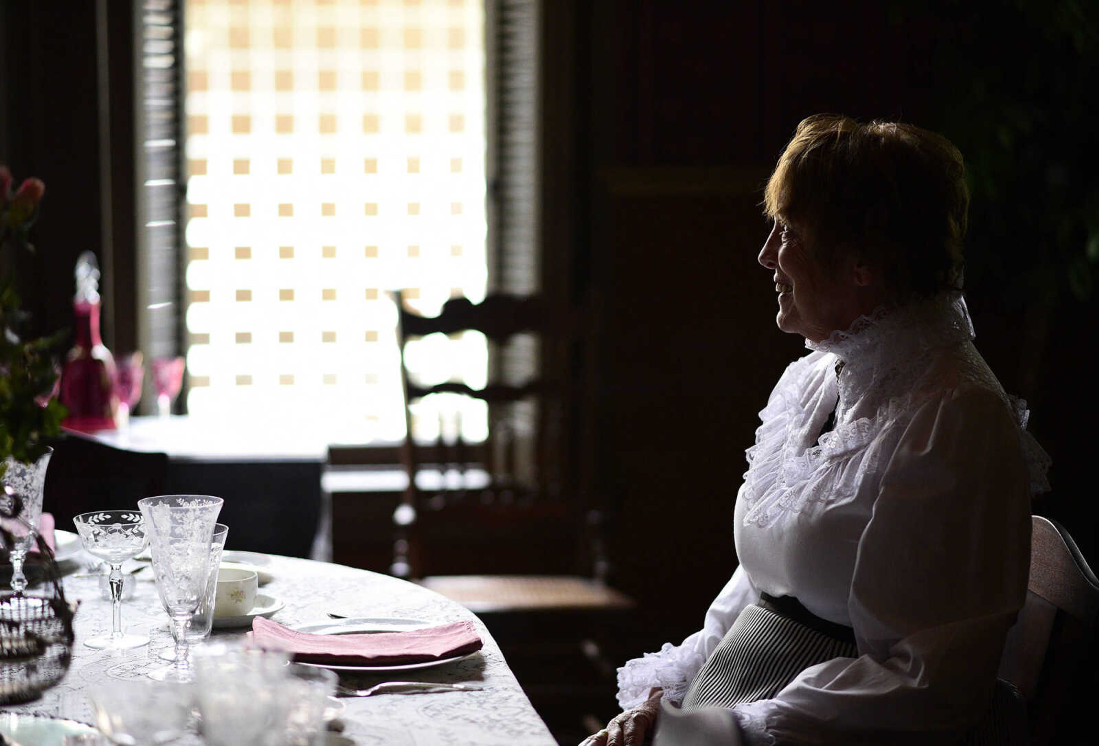 Jane Stephens sits at the dining room table in her period costume on Wednesday, Aug. 16, 2017, inside the Glenn House in Cape Girardeau. KMOS-TV, a PBS affiliate, was filming inside the historic home for its Missouri Life show.