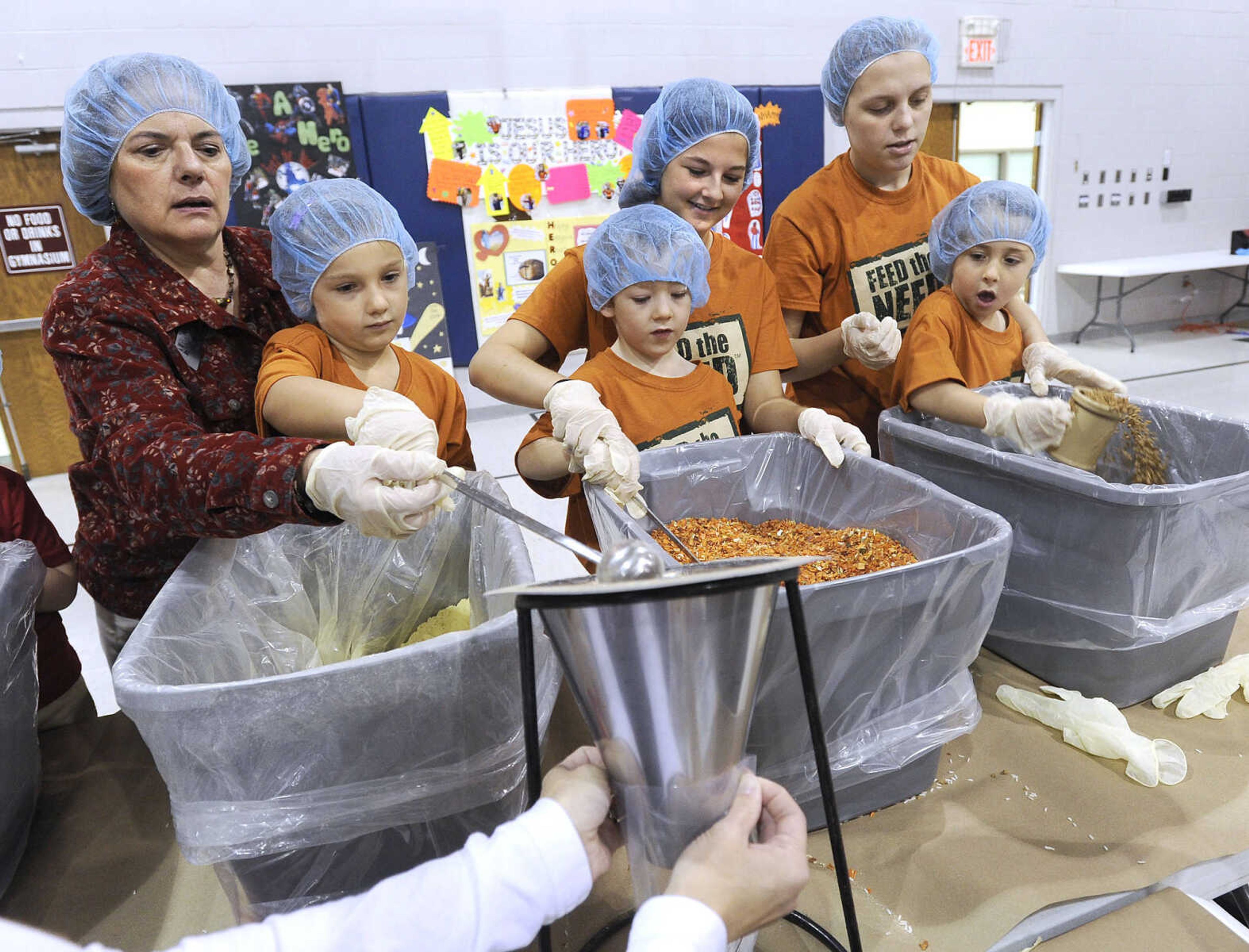 FRED LYNCH ~ flynch@semissourian.com
Volunteers assist pre-kindergarteners at Eagle Ridge Christian School at its second-annual Feed the Need meal-packing event Thursday, Nov. 17, 2016, including, from left, Jane Myers, Kaitlyn DeVault, Thomas Peters, Kaitlyn Todd, Noel Friedrich and Harper Bruce. The school partnered with the Feed the Hunger organization in packing over 10,000 meals that will be shipped to Haiti with a small portion kept for local food banks.