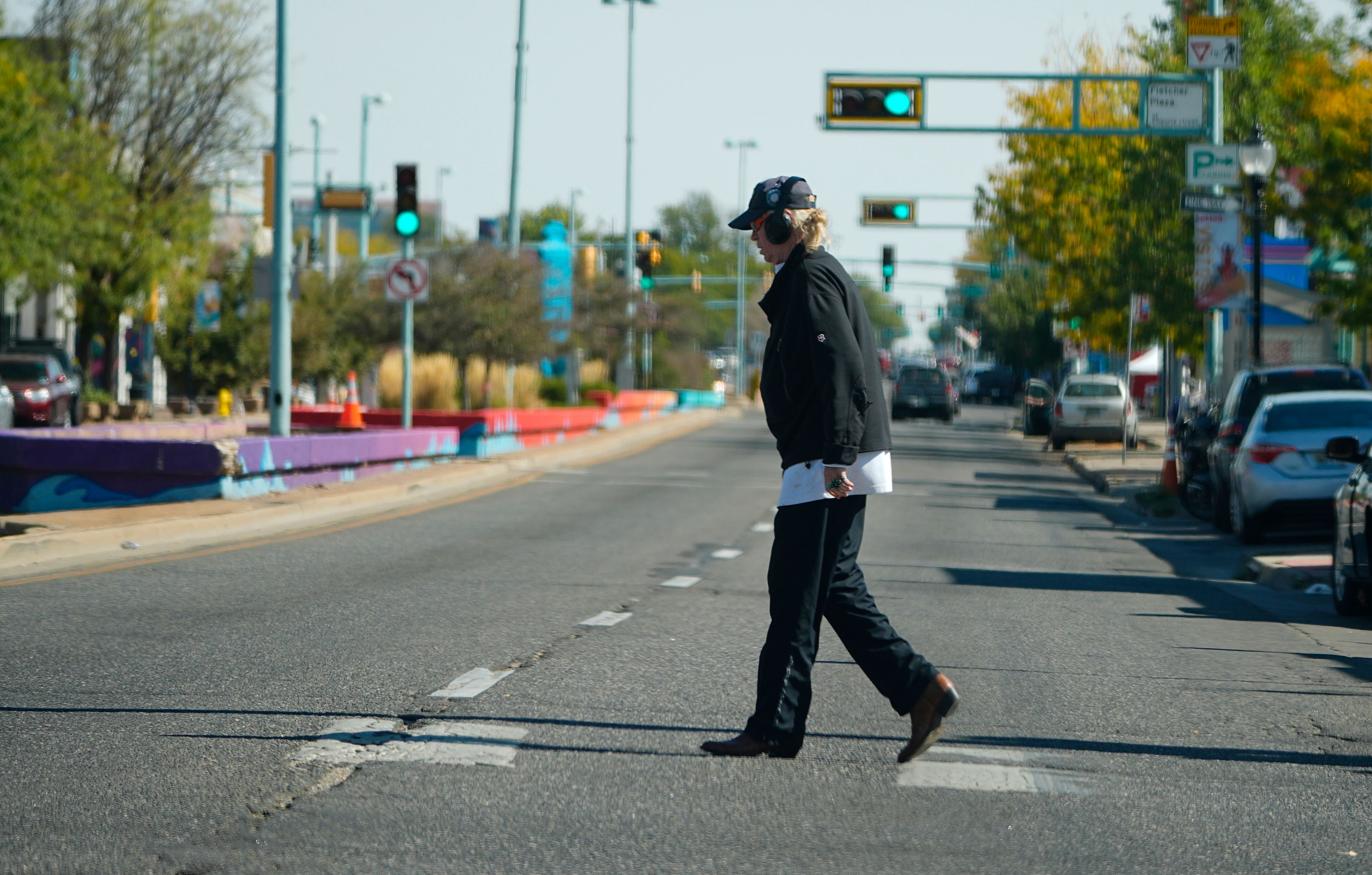 A lone pedestrian crosses East Colfax Avenue at the intersection with Dayton Street, Wednesday, Oct. 9, 2024, in the east Denver suburb of Aurora, Colo. (AP Photo/David Zalubowski)