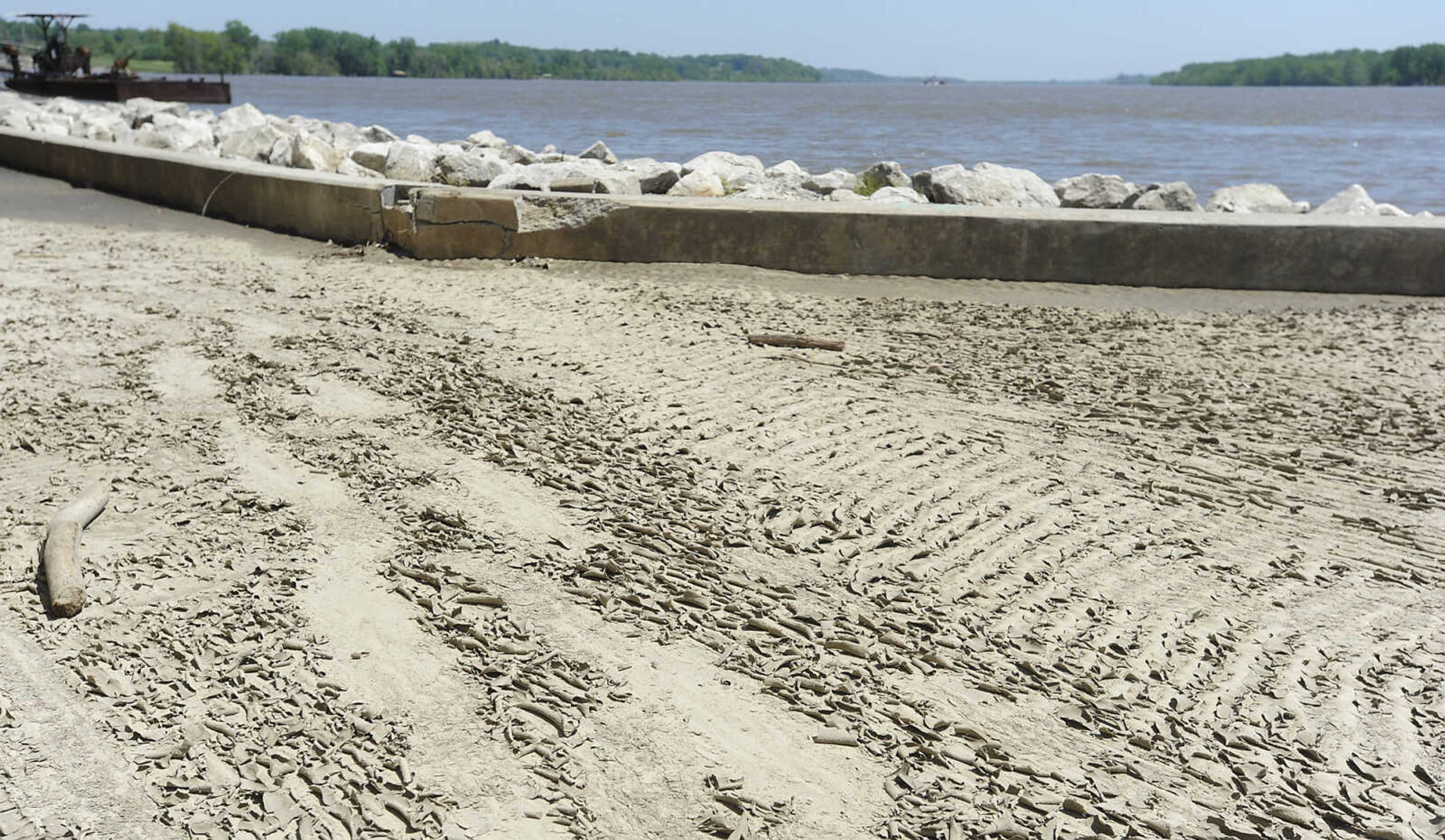 Dirt and mud coat the walking path at Riverfront Park Wednesday, May 15, in Cape Girardeau. The Broadway floodgate has been opened but the floodgate at Themis Street remains closed.