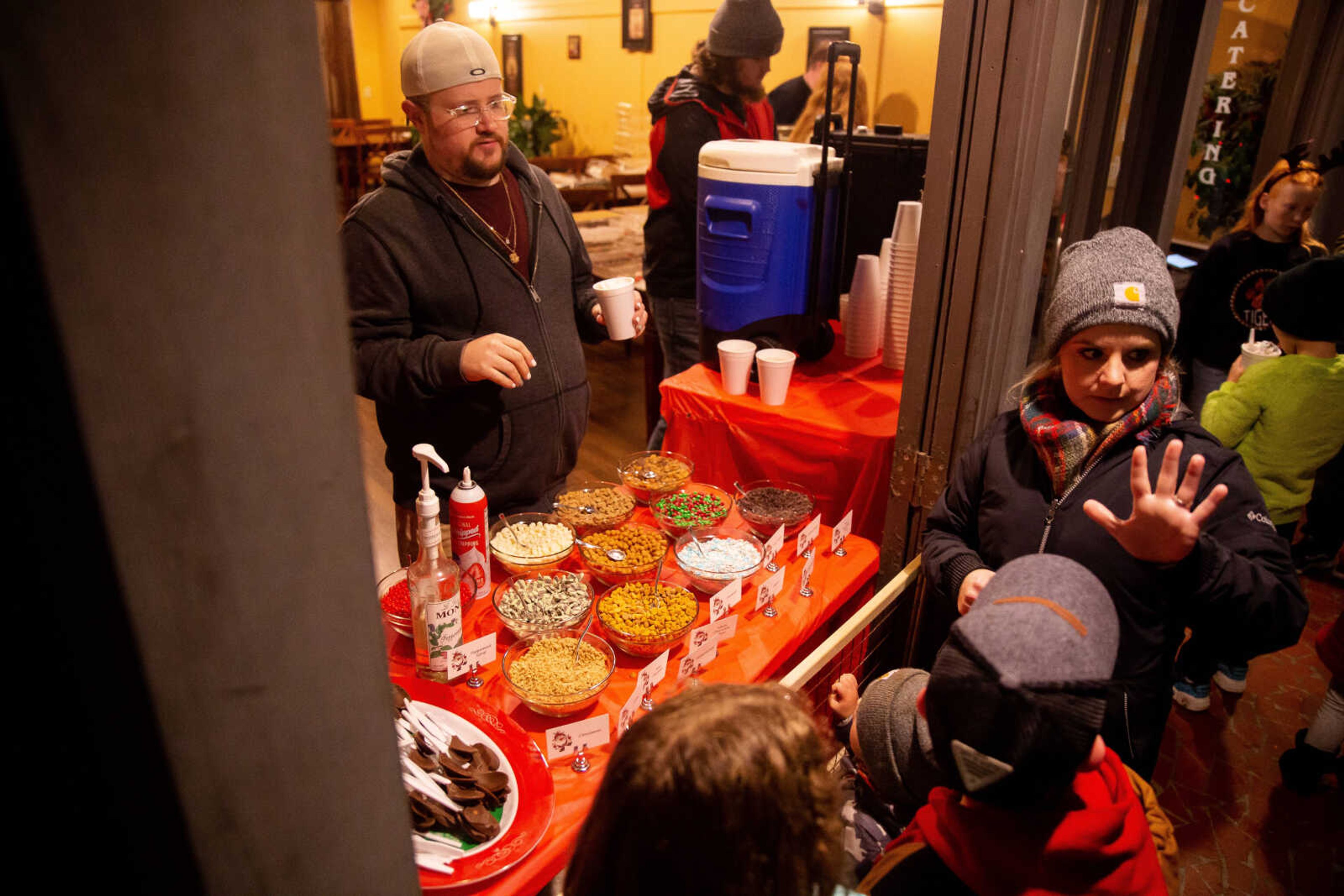 Amanda Pinkerton gestures how many hot chocolates to order at Socials during the Holiday Open House&nbsp;on Friday, Dec. 2 in downtown Cape Girardeau.