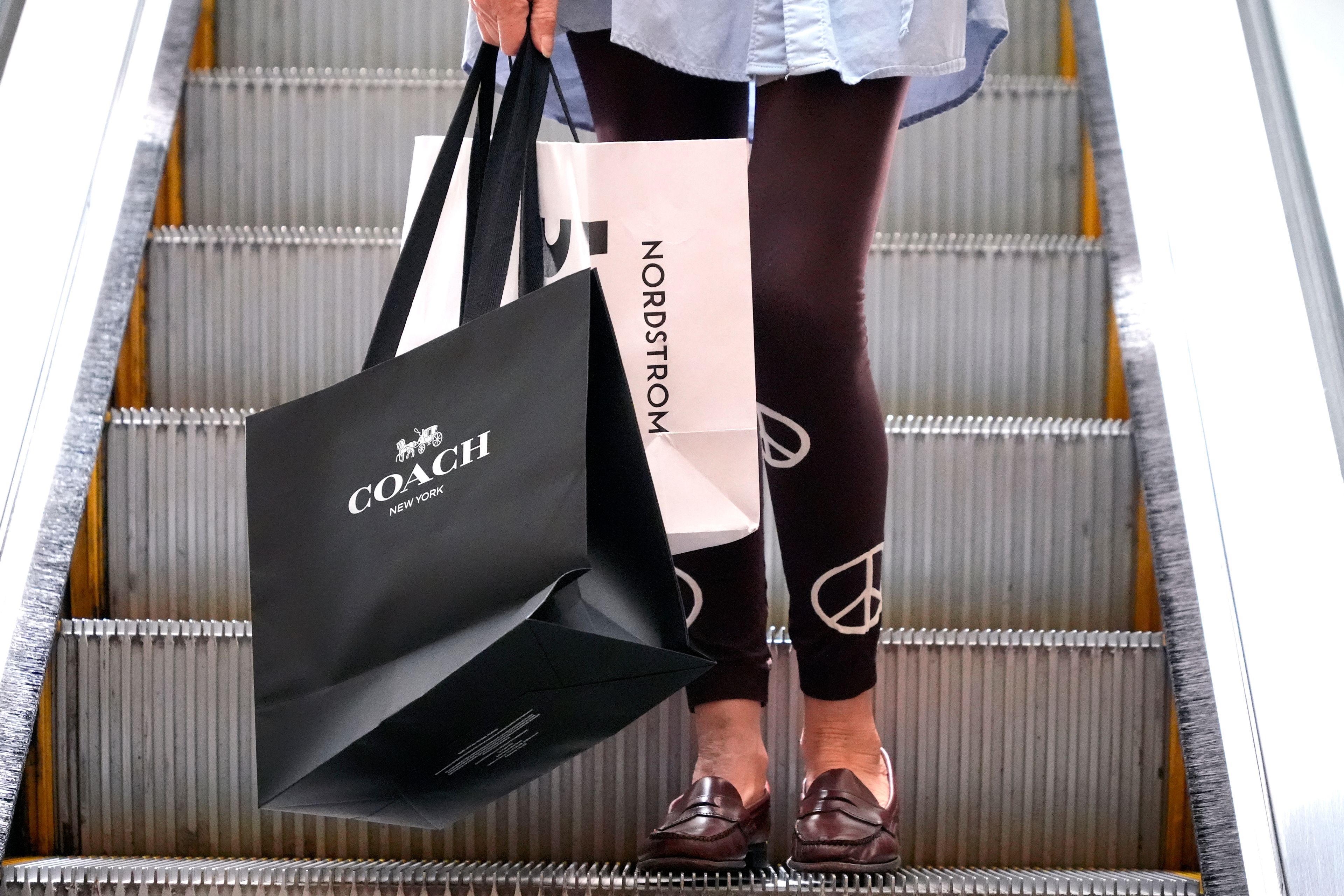 FILE - A shopper carries bags in Pittsburgh on June 3, 2024. (AP Photo/Gene J. Puskar, File)