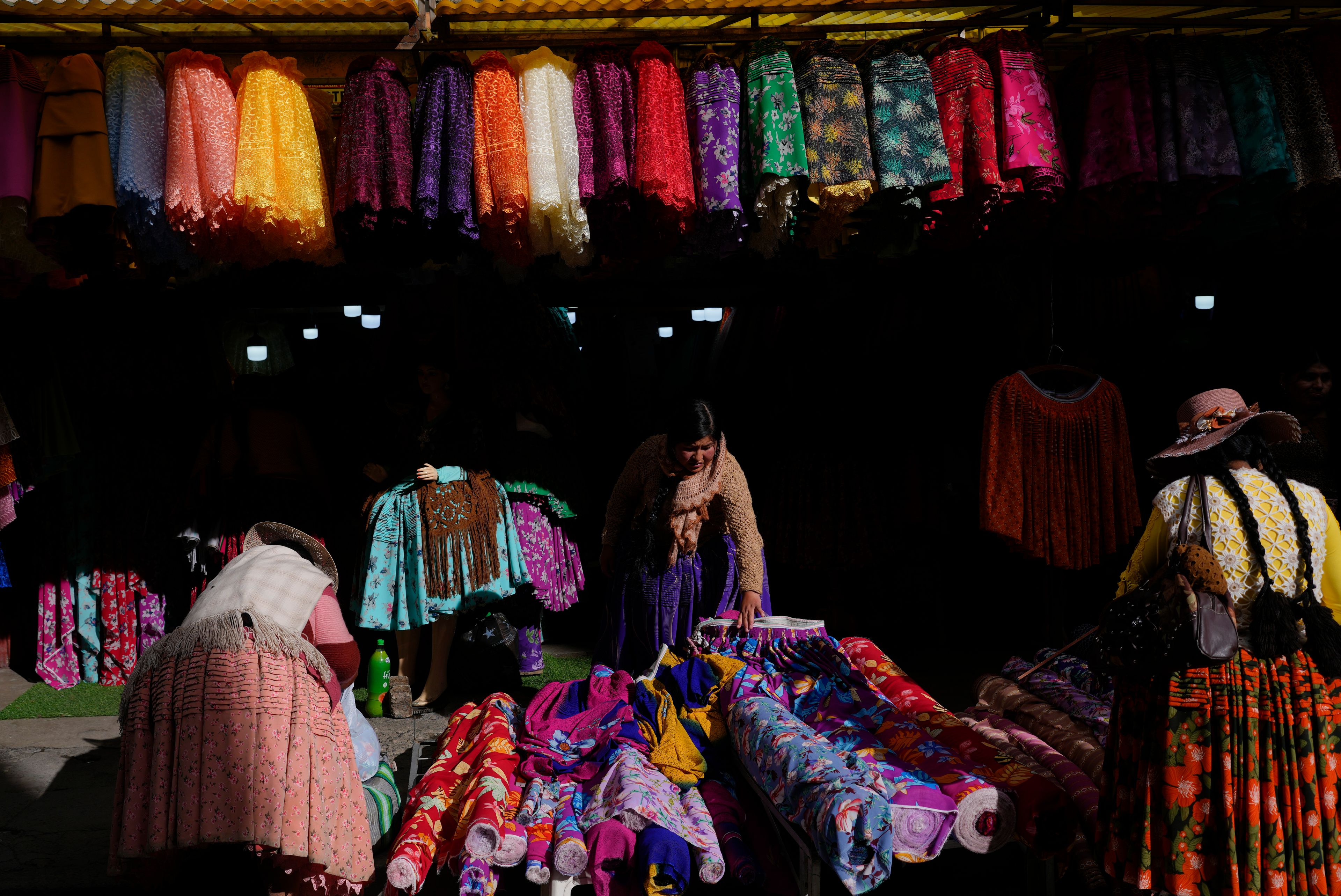 A "chola" skirt vendor makes offers to prospective buyers in El Alto, Bolivia, Nov. 25, 2024. (AP Photo/Juan Karita)