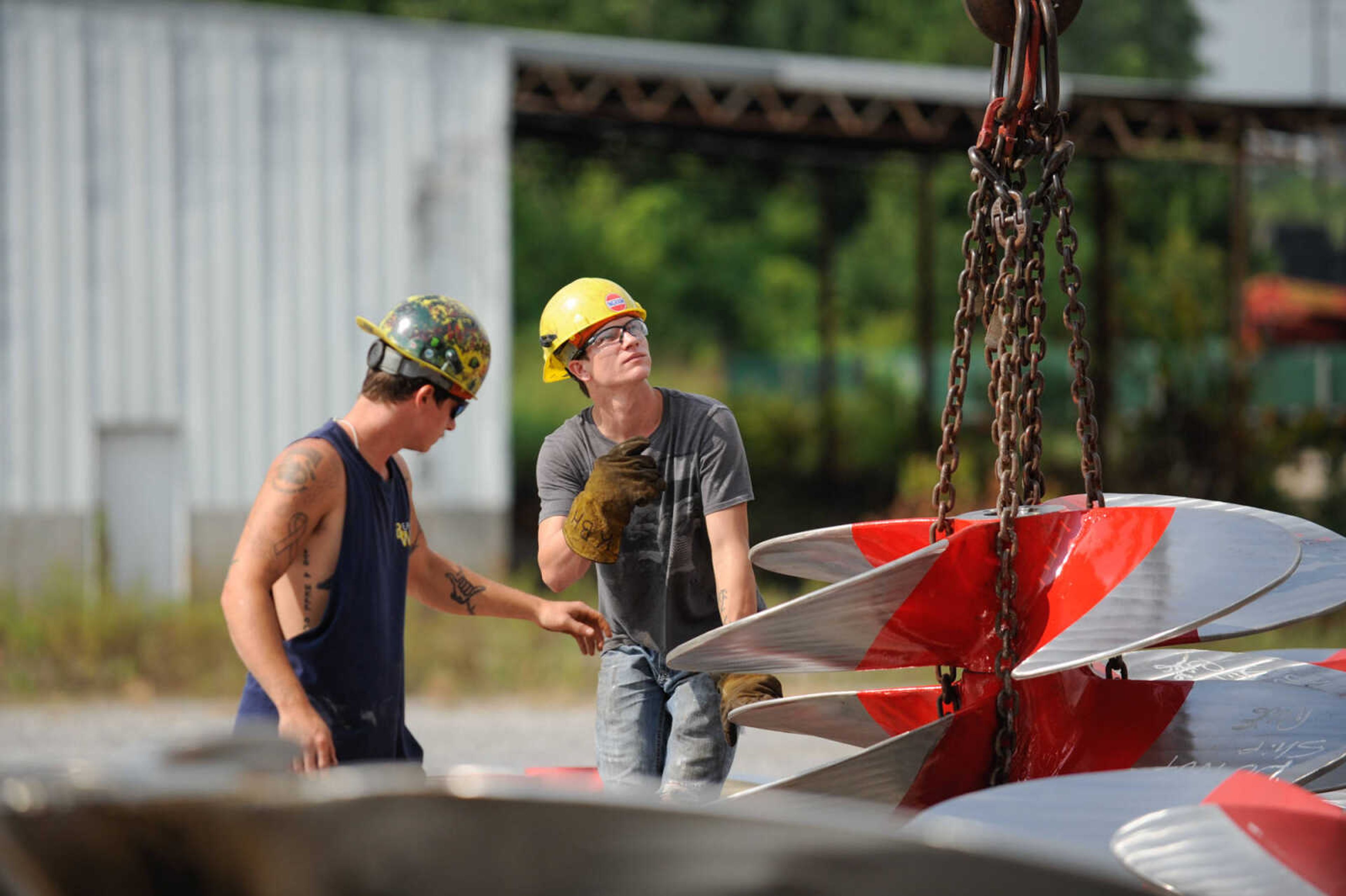 GLENN LANDBERG ~ glandberg@semissourian.com

Cousins, Keegan and Kyler Hale help move propellers in the lot outside the repair shop at Missouri Dry Dock and Repair Co. in Cape Girardeau Wednesday, July 28, 2016.