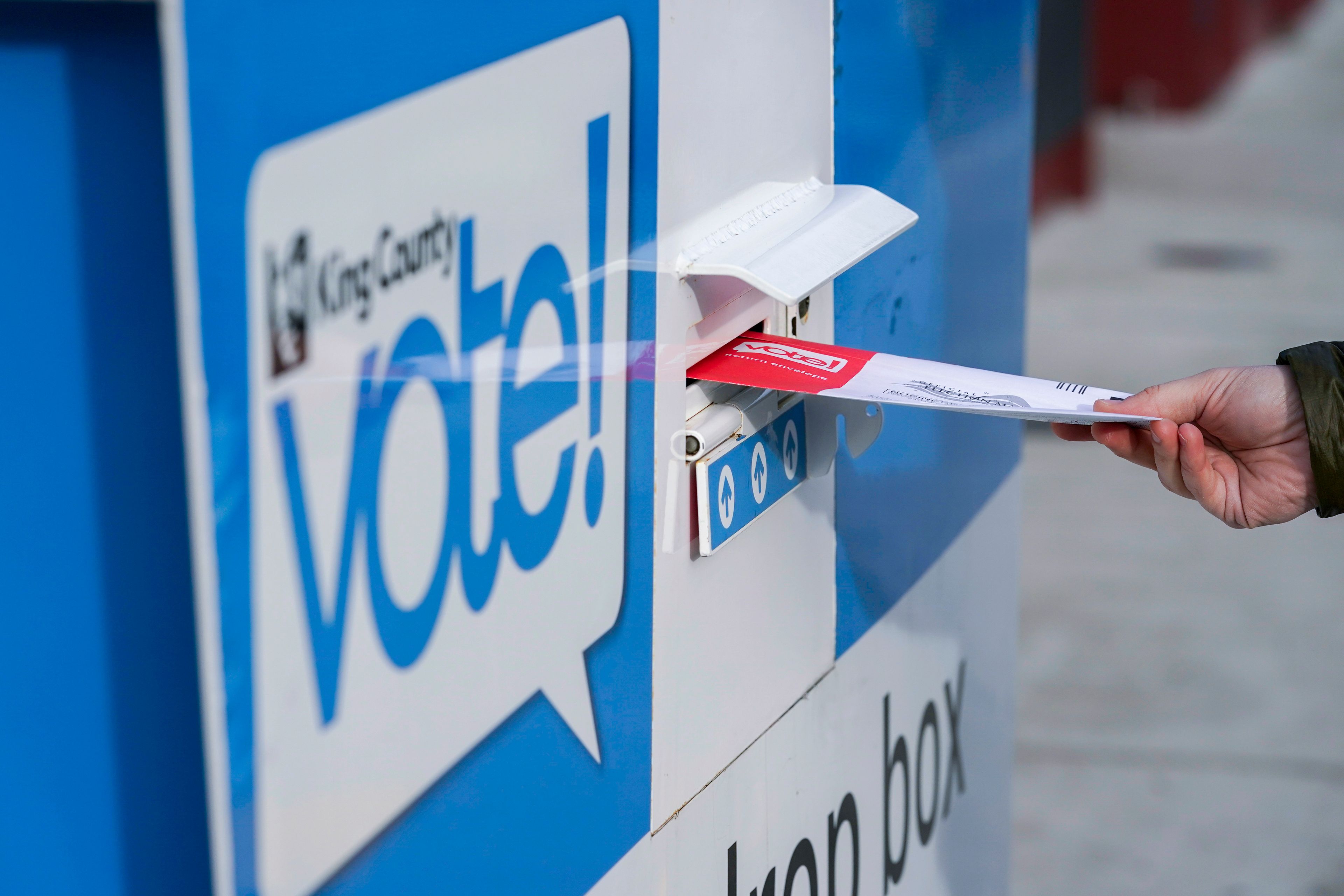 FILE - A person puts their ballot in a drop box at a library in Seattle's White Center neighborhood on Oct. 27, 2020. (AP Photo/Ted S. Warren, File)