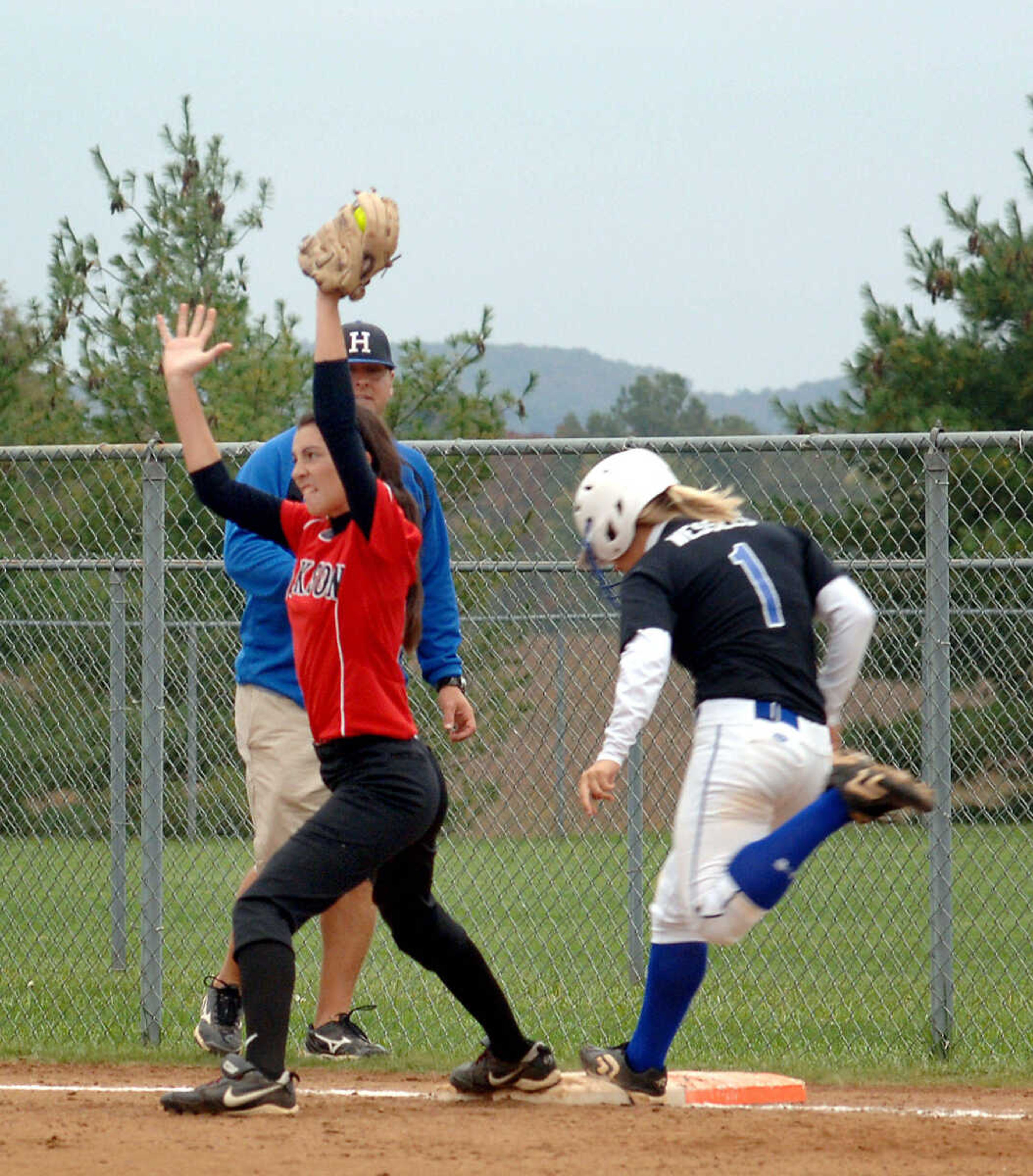 LAURA SIMON~photos@semissourian.com
Jackson's Jessica Jones, left, makes the out at first after Hillsboro's Hannah Wessels hit a ground ball during Monday's district game in Farmington.