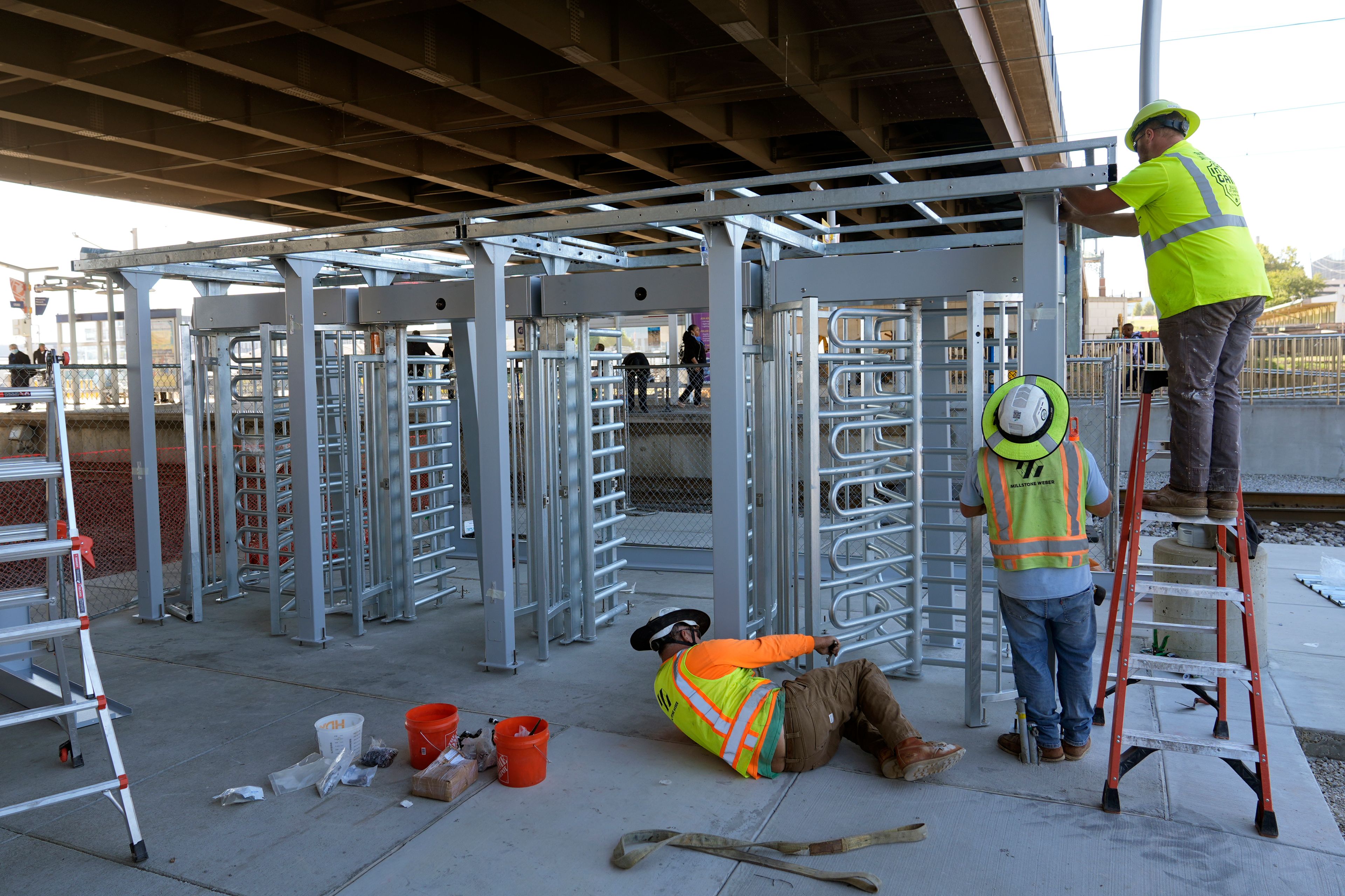 Workers install a metal gate that will prevent customers from entering a MetroLink platform without a valid fare card in an effort to increase security Wednesday, Oct. 9, 2024, in St. Louis. (AP Photo/Jeff Roberson)