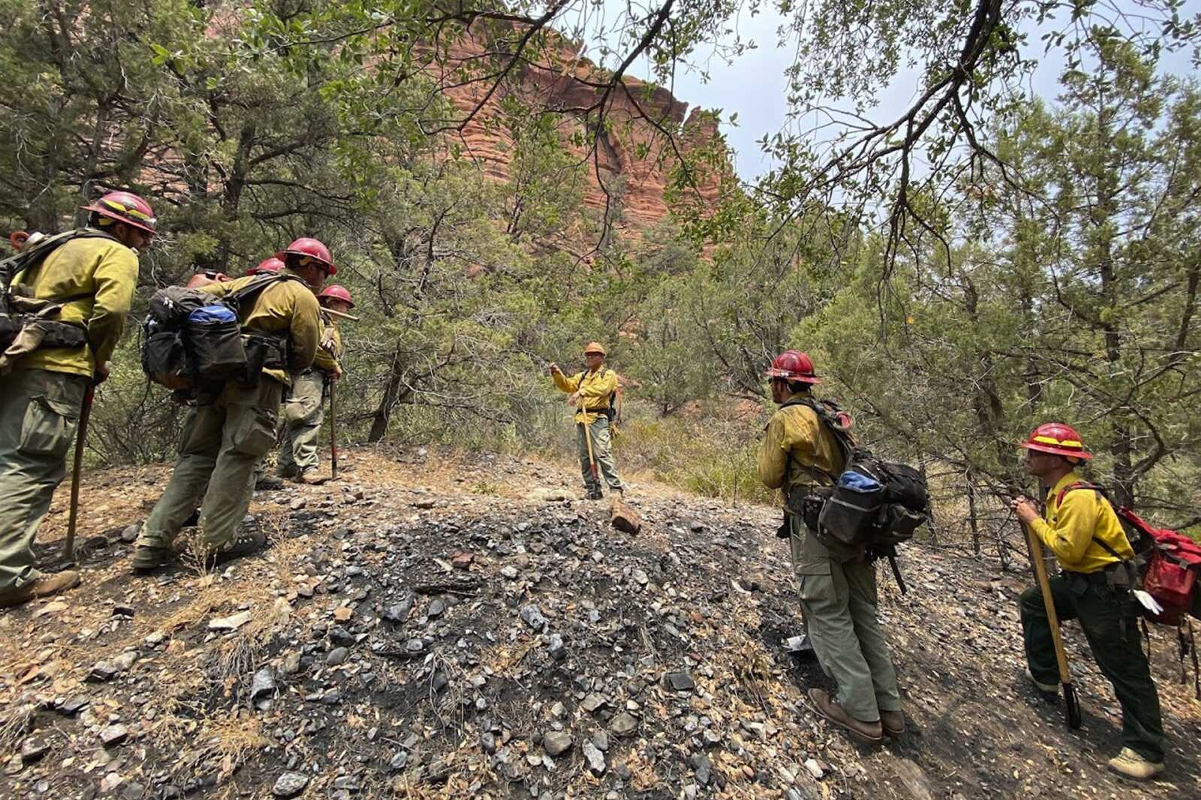 Jason Nez, center, talks to wildland fire personnel working a blaze in 2021 in northern Arizona. Nez is a Navajo archaeologist and firefighter who advises fire officials on how to protect archaeological resources.
