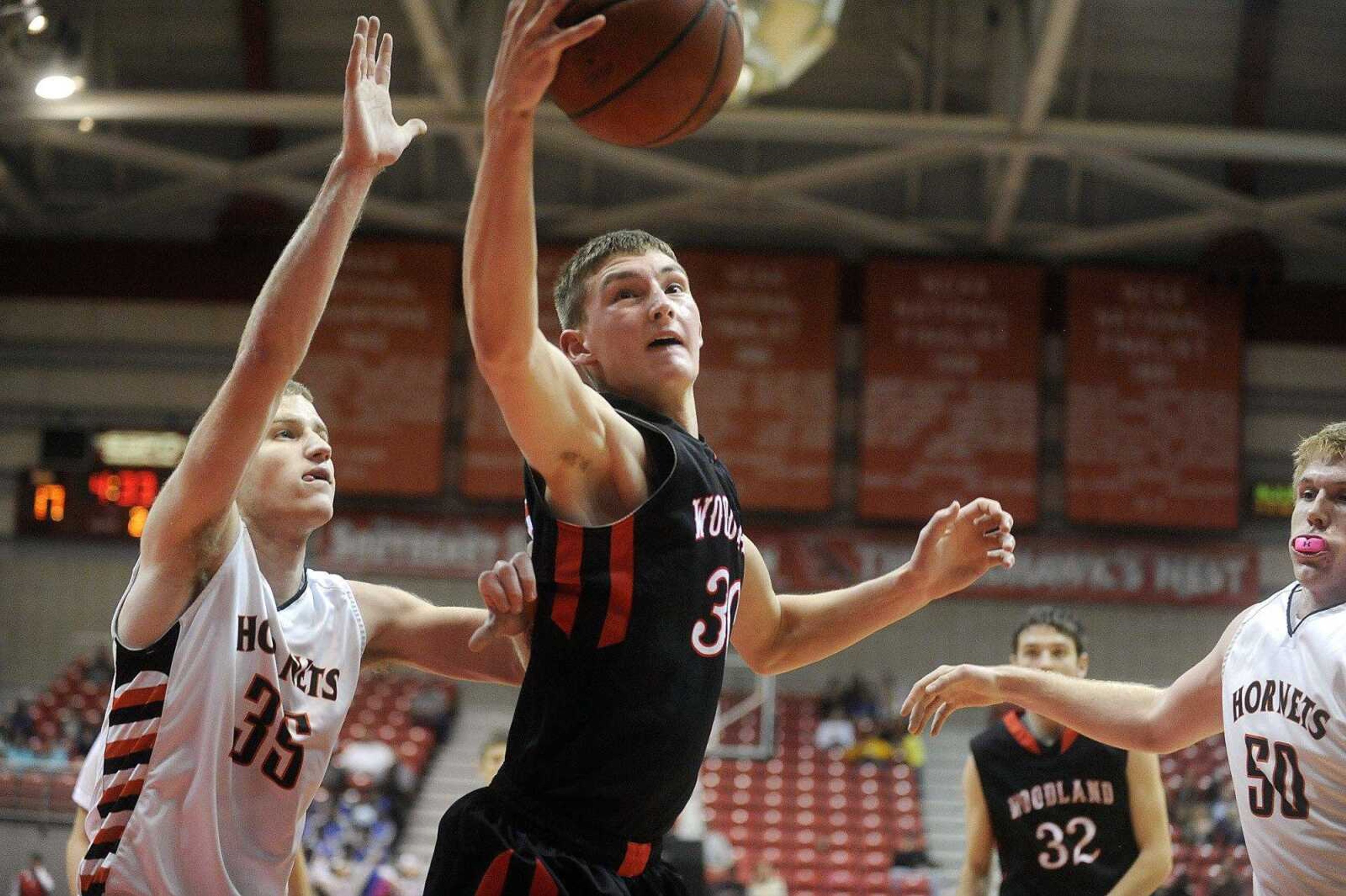 Woodland's Zach Beel rebounds in front of Advance's Dalton Wilson in the second quarter of a consolation championship game, Monday, Dec. 29, 2014, during the Southeast Missourian Christmas Tournament at the Show Me Center. Woodland won 56-52. (Laura Simon)